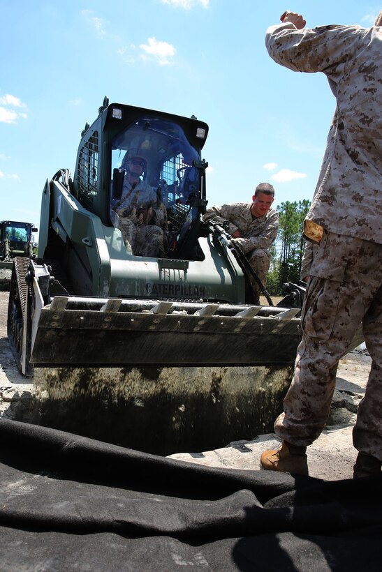 Combat engineers with Marine Wing Support Squadron 271 fill a simulated crater during a Base Recovery After Attack drill at Marine Corps Outlying Field Camp Davis, N.C., Aug. 14, 2014. A BRAAT drill simulates an enemy attack on a base and provides steps to return runways, facilities and essential services to operational conditions.