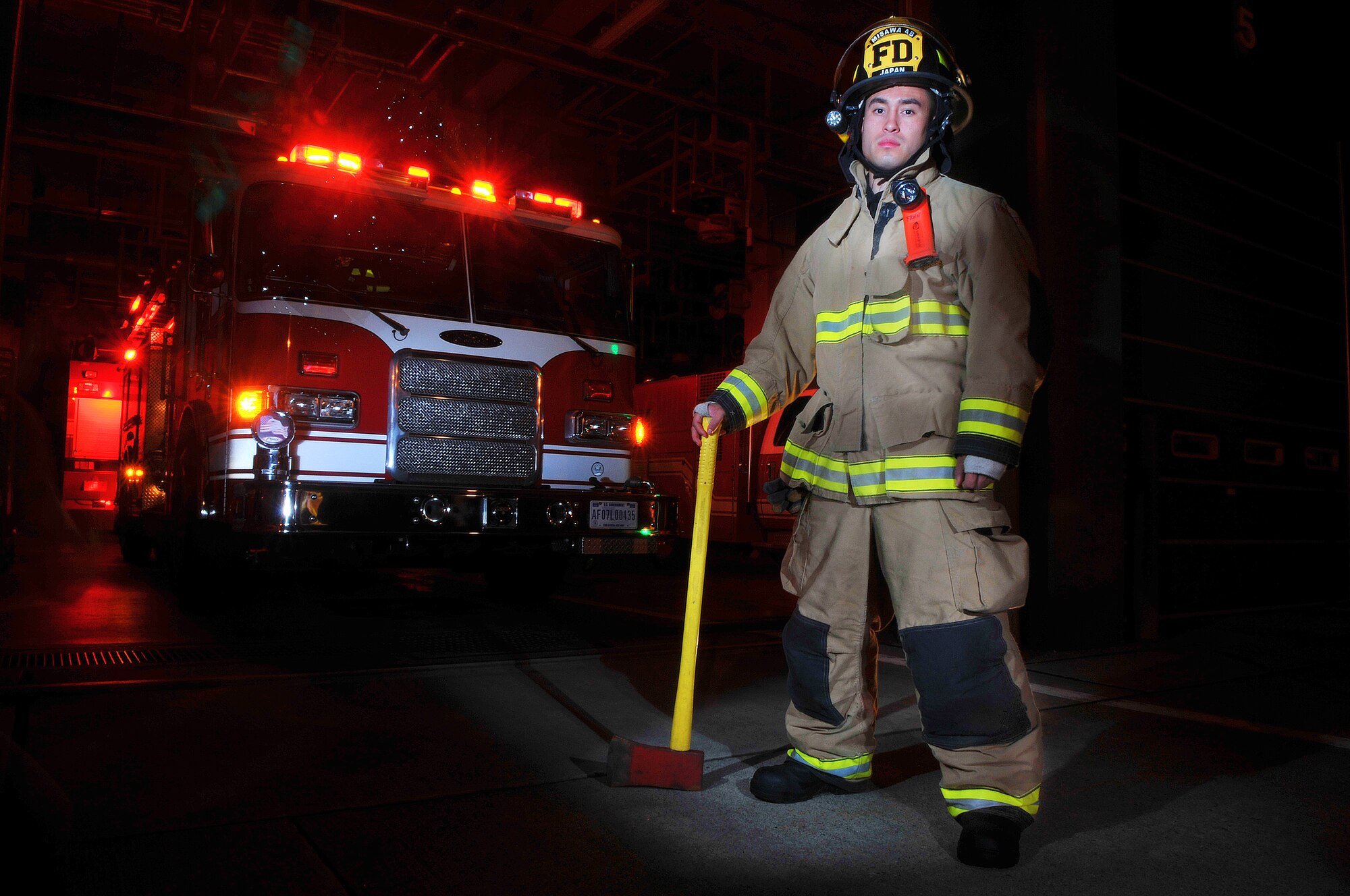 U.S. Air Force Airman 1st Class Edgar Fernandez, 35th Civil Engineer Squadron driver operator, poses in front of his fire emergency response vehicle at Misawa Air Base, Japan, Aug. 13, 2014. Fernandez is tasked with responding to emergency situations to ensure life safety, fire control and property conservation. (U.S. Air Force photo by Senior Airman Jose L. Hernandez-Domitilo)