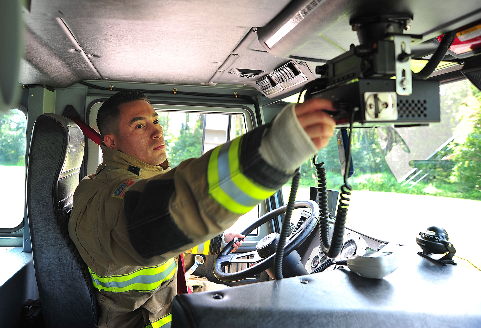 U.S. Air Force Airman 1st Class Edgar Fernandez, 35th Civil Engineer Squadron driver operator, adjusts the channel on his emergency radio system at Misawa Air Base, Japan, Aug. 13, 2014. From initial notification of an emergency, Fernandez has one minute to gear up and be driving out to site. (U.S. Air Force photo by Senior Airman Jose L. Hernandez-Domitilo)