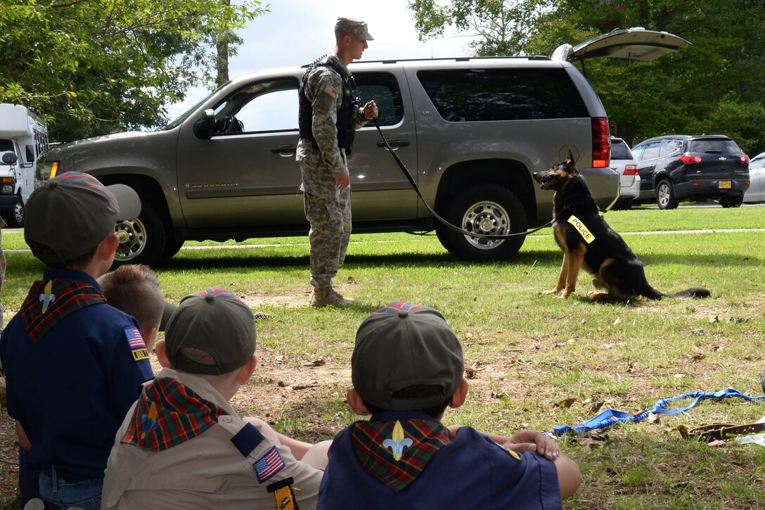 U.S. Army Pfc. Brenan Ward, 3rd Military Police Detachment military working dog handler, conducts obedience training with MWD Chek, a patrol explosives detector dog also assigned to the 3rd MP Det., during the Back to School Block Party at the Teen and Youth Center  at Fort Eustis, Va., Aug. 12, 2014. During the party, the 733rd Security Forces Squadron provided demonstrations including obedience, drug detection, and apprehending a suspect. (U.S. Air Force photo by Staff Sgt. Teresa J.C. Aber/Released)