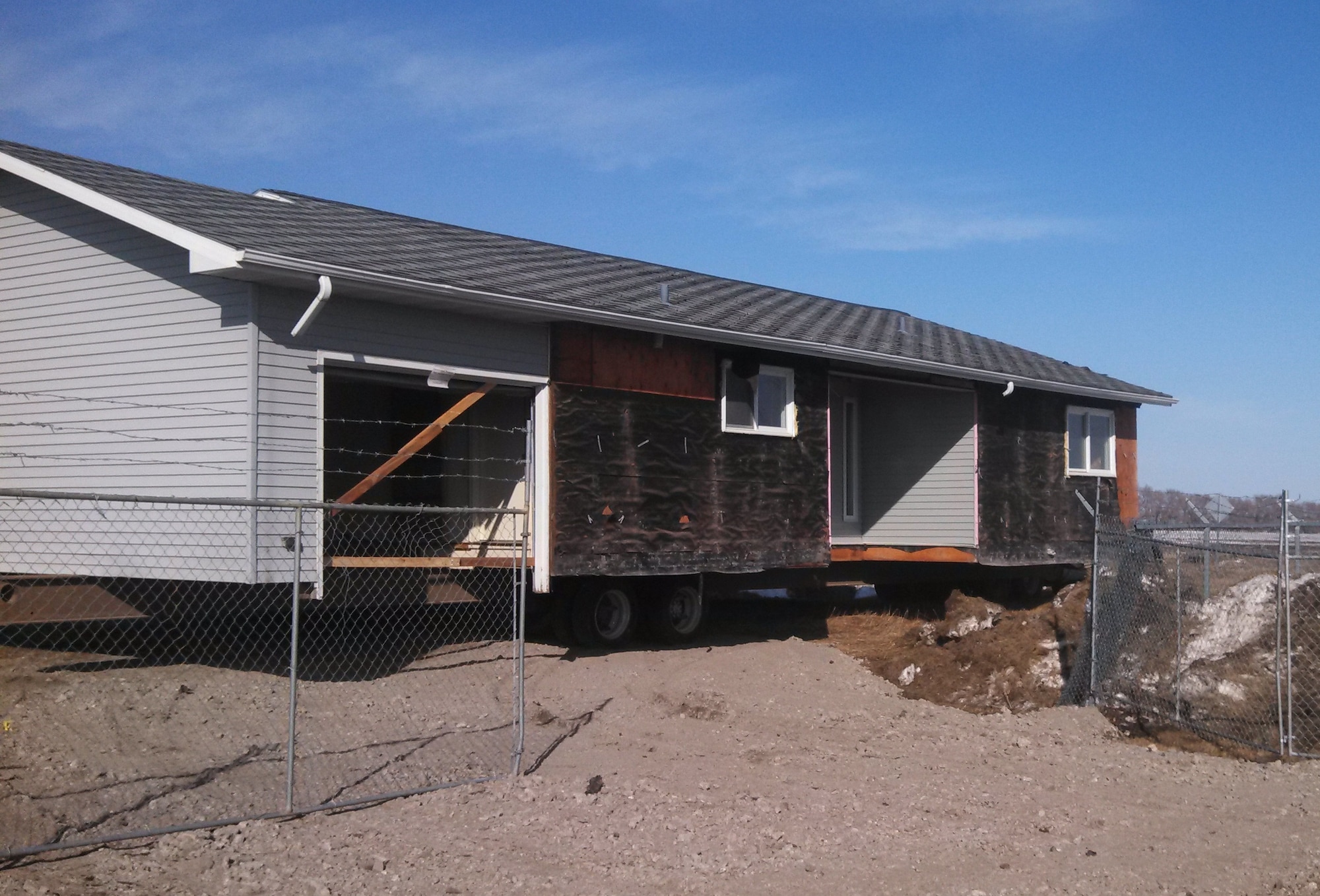 A former Air Force home is hauled away from Grand Forks Air Force Base, N.D., spring of 2014. The home was among the first of 31 units donated this year to the nearby Turtle Mountain Indian Reservation through Operation Walking Shield. The program works to address the chronic overcrowding and homelessness prevalent on American Indian reservations. (Air Force Photo/Cassandra Spradlin)
