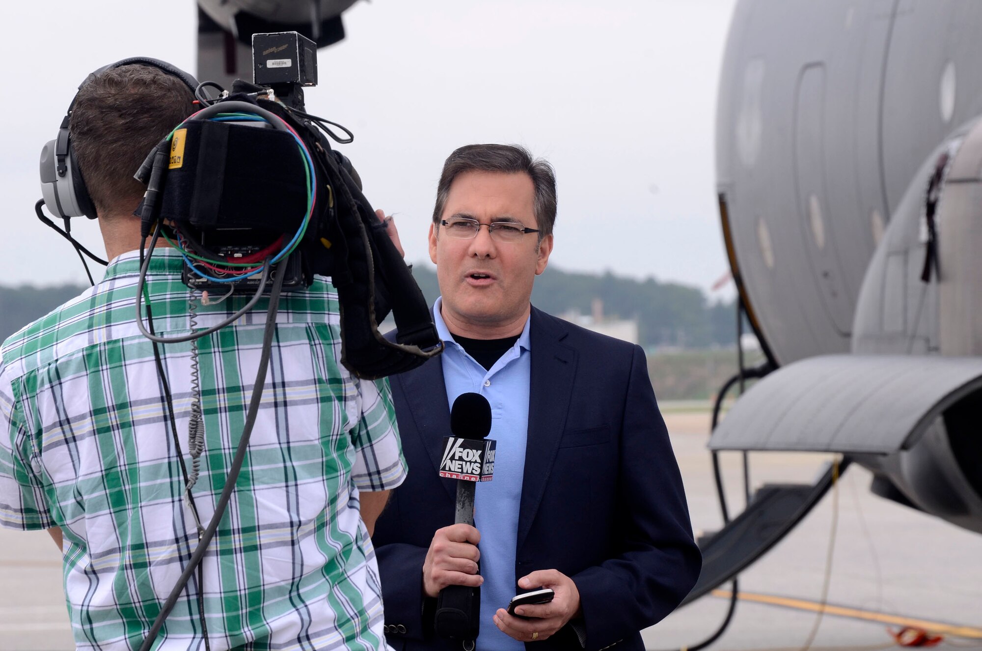 Jonathan Serrie, Fox News Channel correspondent, broadcasts live from the Dobbins Air Reserve Base airfield Aug. 19, 2014 in recognition of the 60th Anniversary of the C-130 aircraft. (U.S. Air Force photo/Don Peek)
