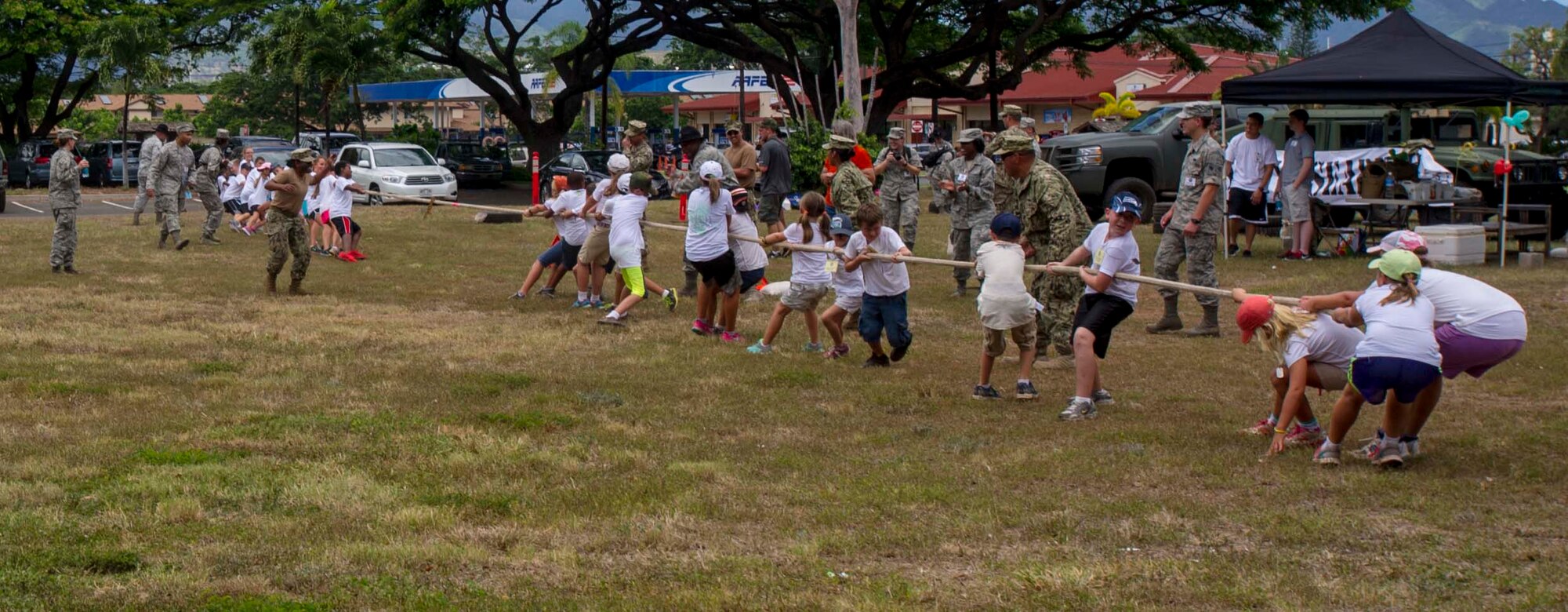 Joint Base Pearl Harbor-Hickam youth play tug-o-war during Operation Hele On Aug. 15, 2014. Hele On is a mock deployment line intended to help children understand the process parents go through before a deployment. More than 130 children attended the full day event which included an intelligence briefing, mobility bag pickup, obstacle course, drill competition, combat arms training and a C-17 static tour. (U.S. Air Force photo by Tech. Sgt. Terri Paden)