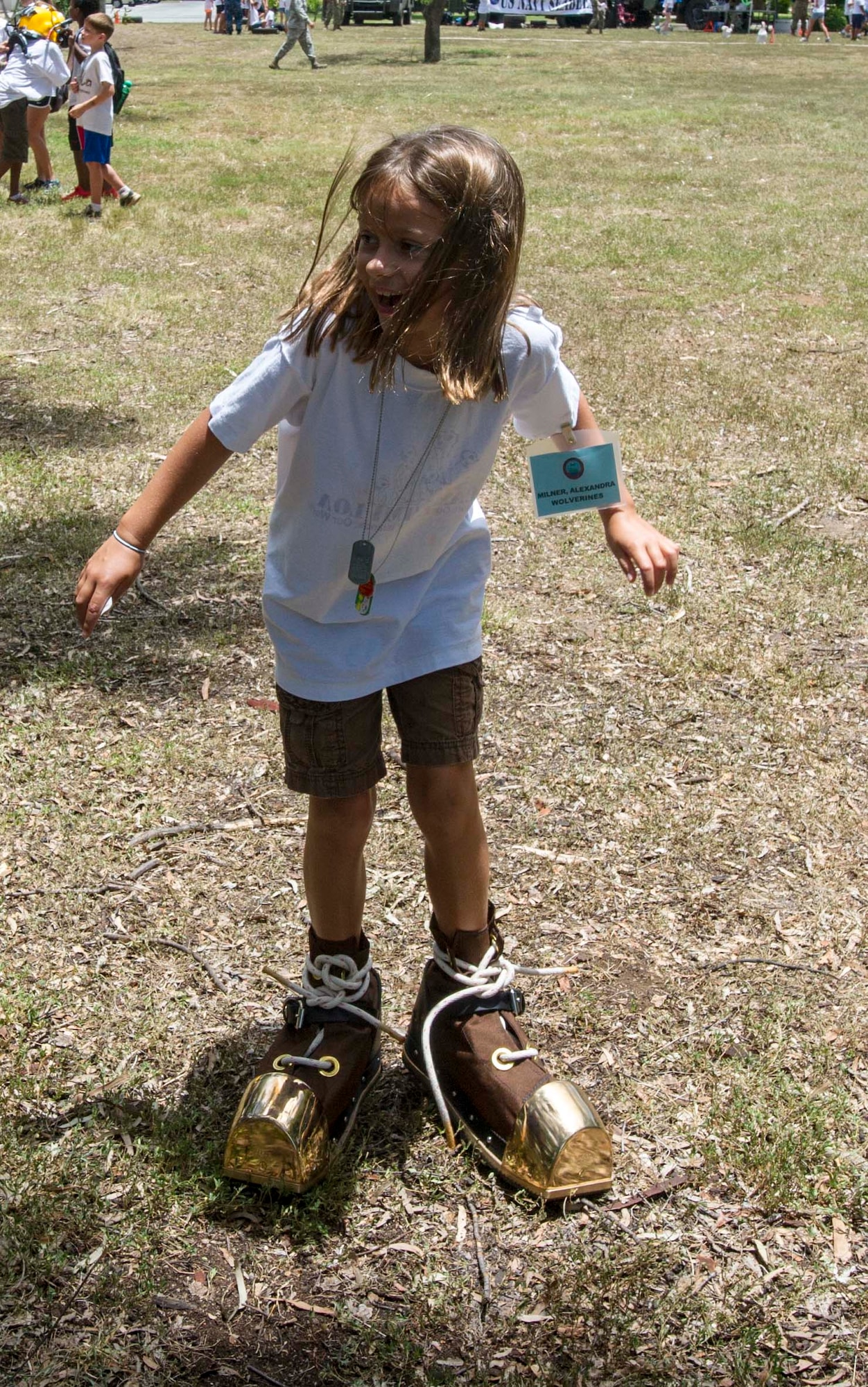 A Joint Base Pearl Harbor-Hickam youth attempts to walk in deep sea boots during Operation Hele On on JBPHH, Hawaii, Aug. 15, 2014. Hele On is a mock deployment line intended to help children understand the process parents go through before a deployment. (U.S. Air Force photo by Tech. Sgt. Terri Paden)