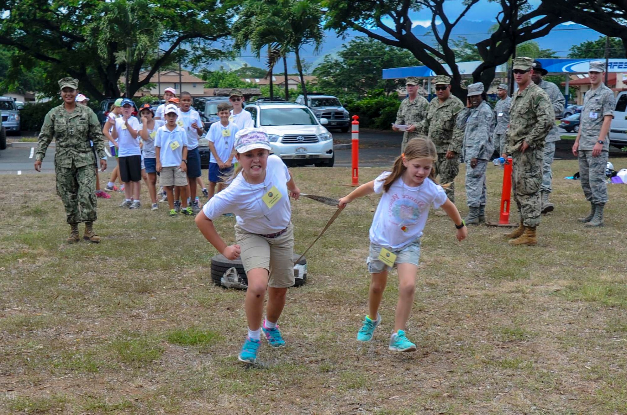 Two Joint Base Pearl Harbor-Hickam youths drag a tire toward the finish line as part of a relay race during Operation Hele On Aug. 15, 2014. Hele On is a mock deployment line intended to help children understand the process parents go through before a deployment. More than 130 children attended the full day event which included an intelligence briefing, mobility bag pickup, obstacle course, drill competition, combat arms training and a C-17 static tour. (U.S. Air Force photo by Tech. Sgt. Terri Paden)