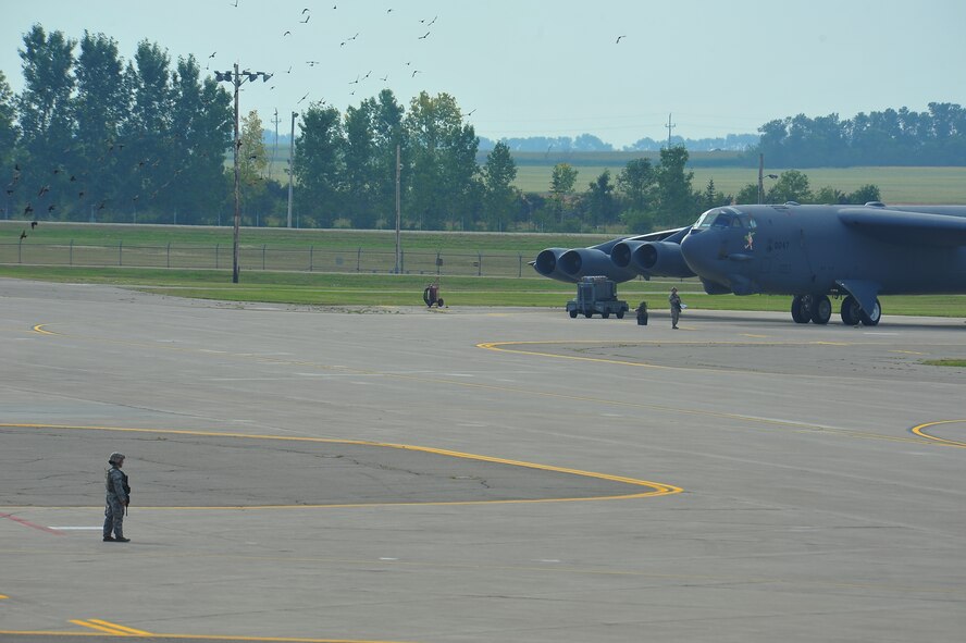 Members of the 5th Security Forces Squadron provide security during a minimum-interval takeoff exercise on Minot Air Force Base, N.D., Aug. 15, 2014. The 5th Bomb Wing routinely conducts training operations and exercises to ensure its forces can perform their mission at any time. (U.S. Air Force photo/Senior Airman Brittany Y. Bateman) 