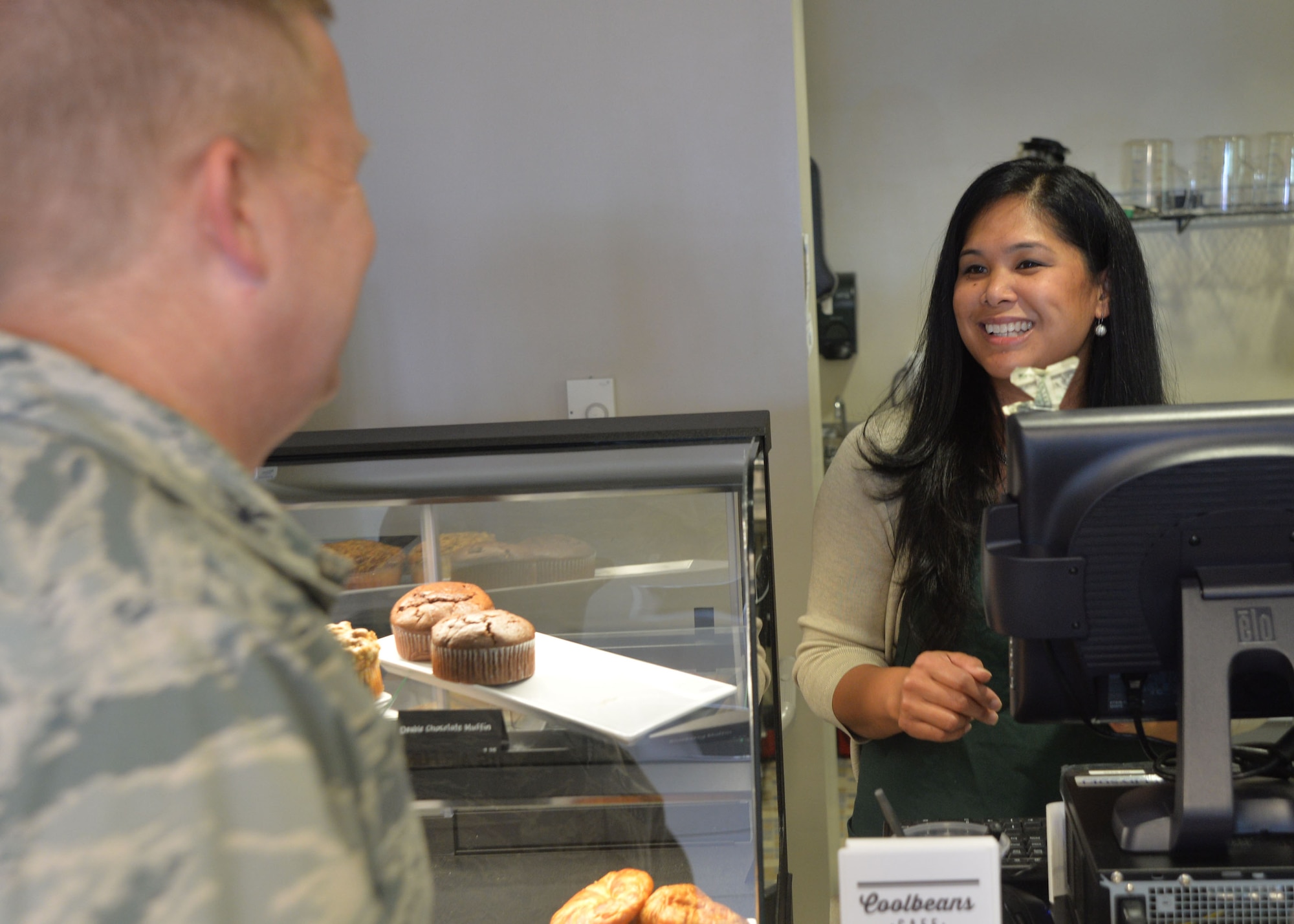 Col. James Cluff, 432nd Wing/432nd Air Expeditionary Wing commander orders a coffee from Roselle Gereda at the grand opening of Coolbeans Café at Creech Air Force Base, Nev. The new coffee shop is located in Building 1003 and is open from 7 a.m. to 4 p.m. Monday through Friday to provide Airmen coffee, snacks and a relaxing atmosphere.  (U.S. Air Force photo by Tech. Sgt. Nadine Barclay/Released)