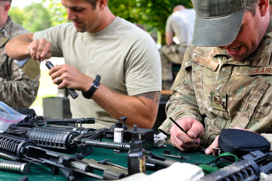 U.S. Air Force Tech. Sgt. Brent M. Troyer (right) and Staff Sgt. Cody L. Canfield, both tactical air control party specialists with the 169th Air Support Operations Squadron, clean  their M4 carbines after a weapons qualification at Operation Northern Strike in Alpena, Mich., Aug. 15, 2014. Northern Strike was a 3-week-long exercise led by the National Guard that demonstrated the combined power of joint and multinational air and ground forces. TACPs with the Air National Guard’s 169th ASOS from Peoria, Ill., and more than 5,000 other armed forces members from 12 states and two coalition nations participated in the combat training. (U.S. Air National Guard photo by Staff Sgt. Lealan Buehrer/Released)