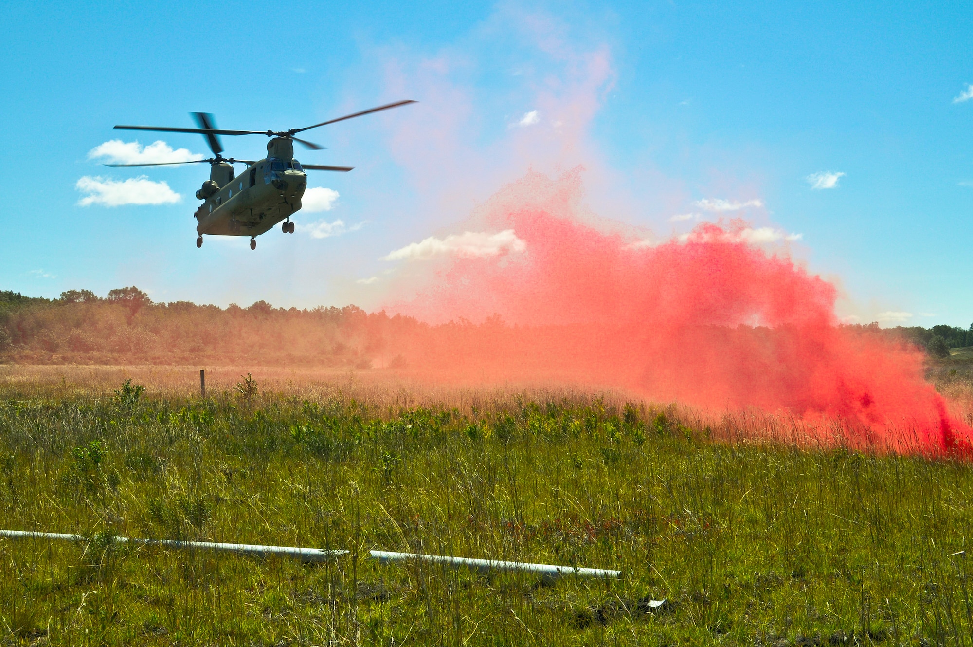 A CH-47 Chinook descends on a landing zone to pick up TACPs from the U.S. Air Force 169th Air Support Operations Squadron and the Latvian National Armed Forces after a reconnaissance mission at Operation Northern Strike in Grayling Air Gunnery Range, Grayling, Mich., Aug. 14, 2014. Northern Strike was a 3-week-long exercise led by the National Guard that demonstrated the combined power of joint and multinational air and ground forces. TACPs with the Air National Guard’s 169th ASOS from Peoria, Ill., and more than 5,000 other armed forces members from 12 states and two coalition nations participated in the combat training. (U.S. Air National Guard photo by Staff Sgt. Lealan Buehrer/Released)