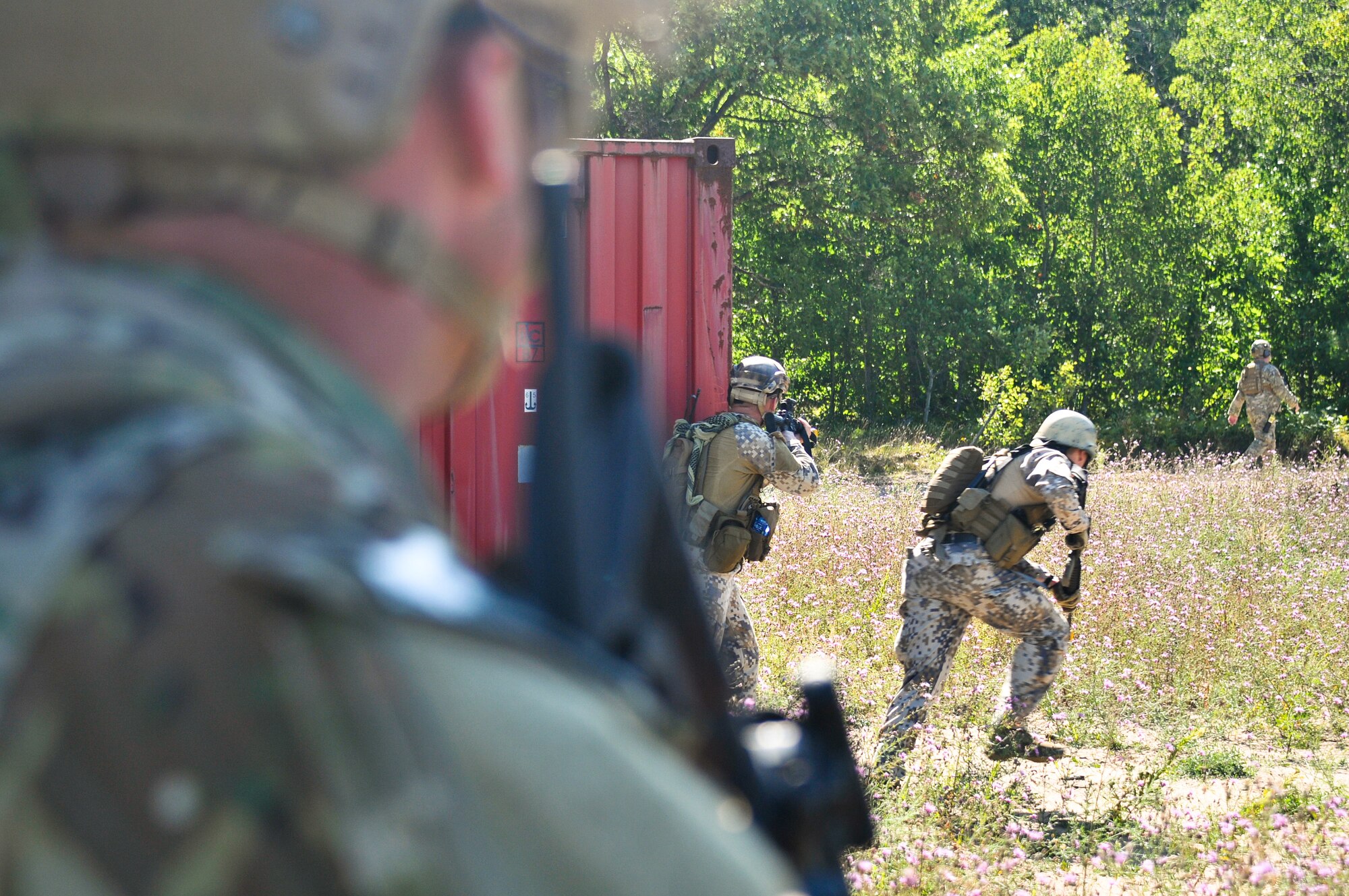 Tactical air control party specialists with the Latvian National Armed Forces advance on enemy forces while a TACP with the 169th Air Support Operations Squadron provides cover fire after an ambush during a reconnaissance mission at Operation Northern Strike in Grayling Air Gunnery Range, Grayling, Mich., Aug. 14, 2014. Northern Strike was a 3-week-long exercise led by the National Guard that demonstrated the combined power of joint and multinational air and ground forces. TACPs with the Air National Guard’s 169th ASOS from Peoria, Ill., and more than 5,000 other armed forces members from 12 states and two coalition nations participated in the combat training. (U.S. Air National Guard photo by Staff Sgt. Lealan Buehrer/Released)
