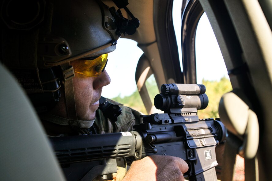 U.S. Air Force Master Sgt. John M. Oliver, a tactical air control party specialist with the 169th Air Support Operations Squadron, fires out of a moving vehicle at enemy forces during a reconnaissance mission at Operation Northern Strike in Grayling Air Gunnery Range, Grayling, Mich., Aug. 14, 2014. Northern Strike was a 3-week-long exercise led by the National Guard that demonstrated the combined power of joint and multinational air and ground forces. TACPs with the Air National Guard’s 169th ASOS from Peoria, Ill., and more than 5,000 other armed forces members from 12 states and two coalition nations participated in the combat training. (U.S. Air National Guard photo by Staff Sgt. Lealan Buehrer/Released)