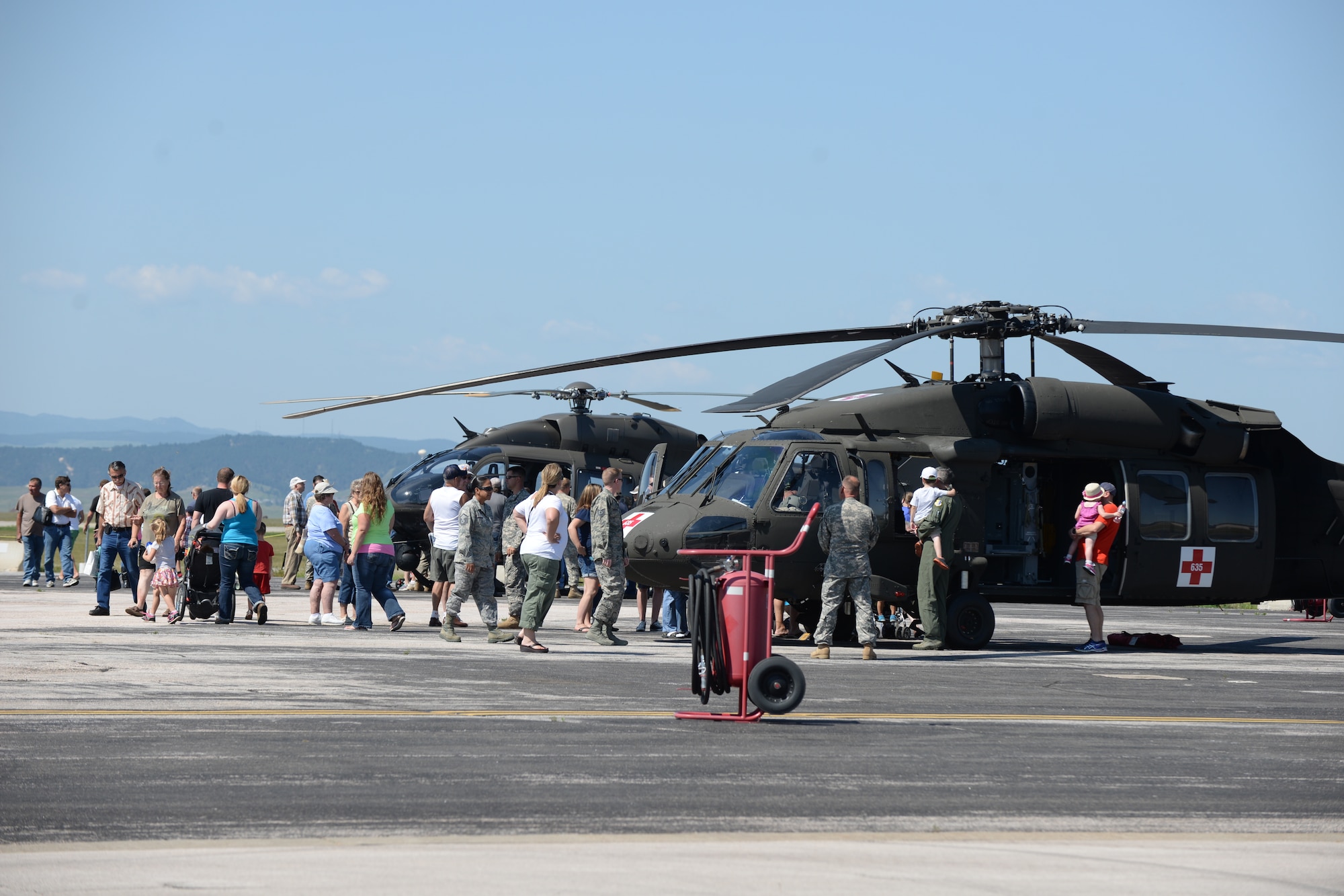 Community members, Airmen and their families tour a UH-72 Lakota and UH-60 Black Hawk helicopters assigned to the South Dakota Army National Guard during Ellsworth’s Black Hills Community Appreciation Day at Ellsworth Air Force Base, S.D., Aug. 16, 2014. The event was open for all members of the community to come on base and learn more about Ellsworth’s mission, as well as give Airmen a chance to thank the surrounding communities for their support of the base. (U.S. Air Force photo by Senior Airman Zachary Hada/Released)