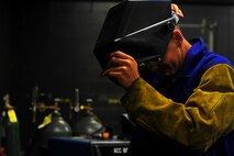 Senior Airman Matthew Vley, 5th Maintenance Squadron metals technician, dons his welding mask on Minot Air Force Base, N.D., Aug. 7, 2014. Vley is performing a task for his welding certifications. (U.S. Air Force photo/Senior Airman Brittany Y. Bateman)
