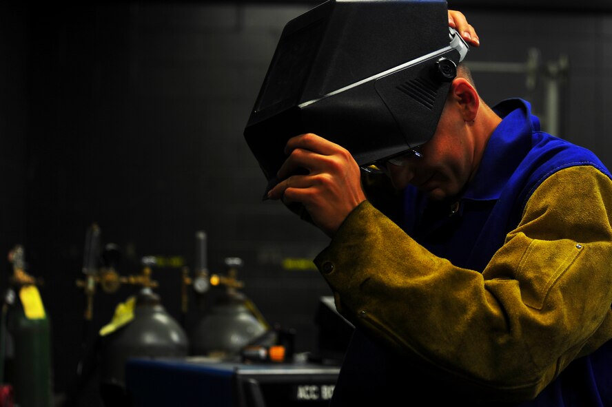 Senior Airman Matthew Vley, 5th Maintenance Squadron metals technician, dons his welding mask on Minot Air Force Base, N.D., Aug. 7, 2014. Vley is performing a task for his welding certifications. (U.S. Air Force photo/Senior Airman Brittany Y. Bateman)