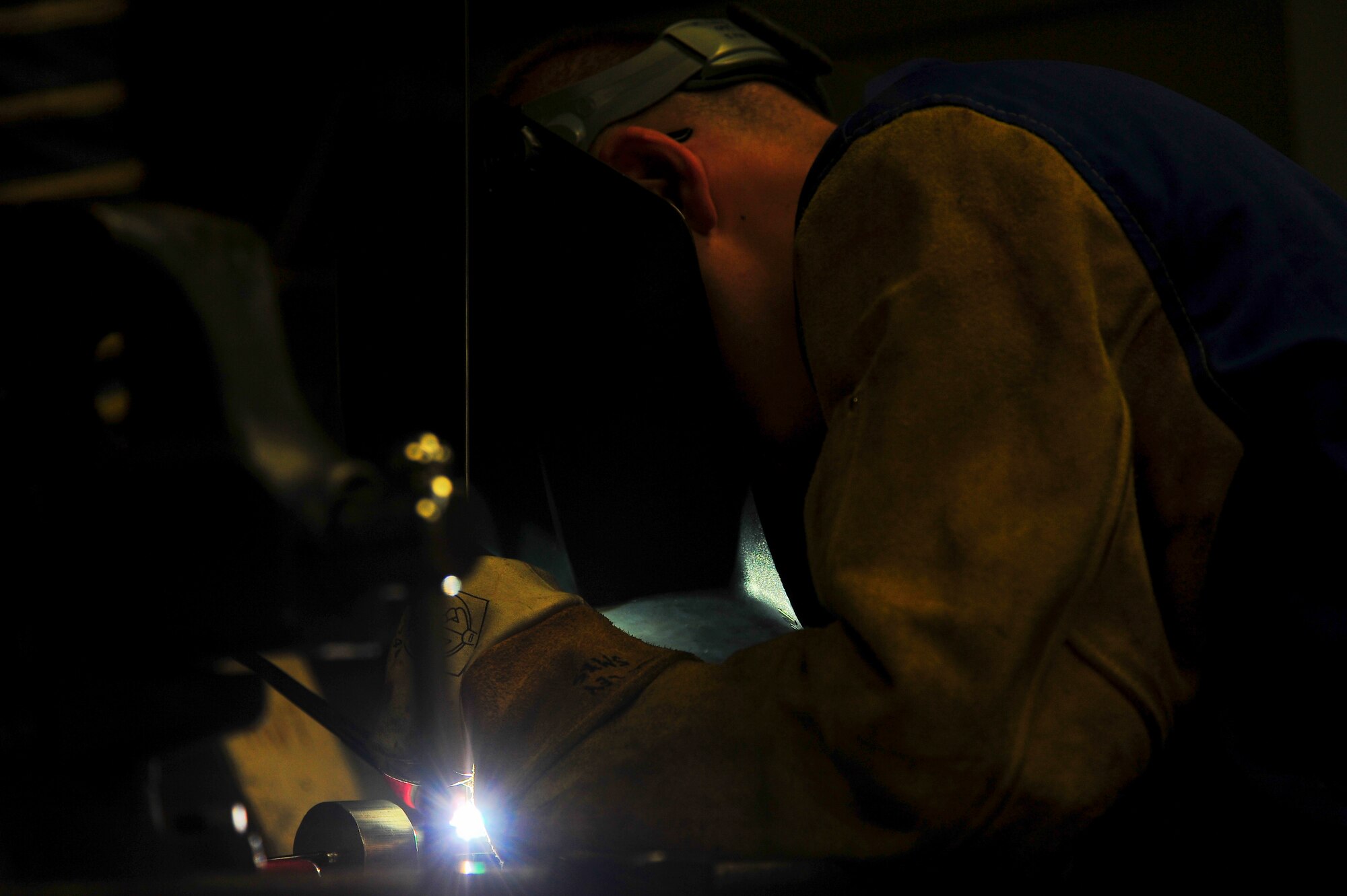 Senior Airman Matthew Vley, 5th Maintenance Squadron metals technician, welds a piece of metal during his weld certification on Minot Air Force Base, N.D., Aug. 7, 2014. Metals technicians from the 5th MXS use a lathe, drill press, torch and imagination to repair, and at times create parts that are no longer available. (U.S. Air Force photo/Senior Airman Brittany Y. Bateman)