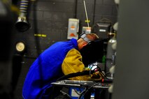 Senior Airman Matthew Vley, 5th Maintenance Squadron metals technician, welds a piece of metal during his weld certification on Minot Air Force Base, N.D., Aug. 7, 2014. Metals technicians from the 5th MXS use a lathe, drill press, torch and imagination to repair, and at times create parts that are no longer available. (U.S. Air Force photo/Senior Airman Brittany Y. Bateman)