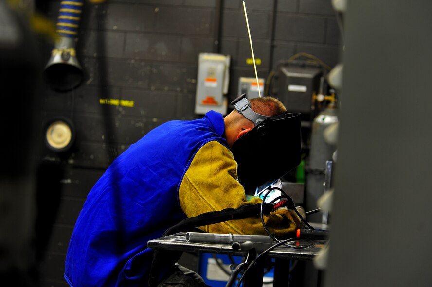 Senior Airman Matthew Vley, 5th Maintenance Squadron metals technician, welds a piece of metal during his weld certification on Minot Air Force Base, N.D., Aug. 7, 2014. Metals technicians from the 5th MXS use a lathe, drill press, torch and imagination to repair, and at times create parts that are no longer available. (U.S. Air Force photo/Senior Airman Brittany Y. Bateman)