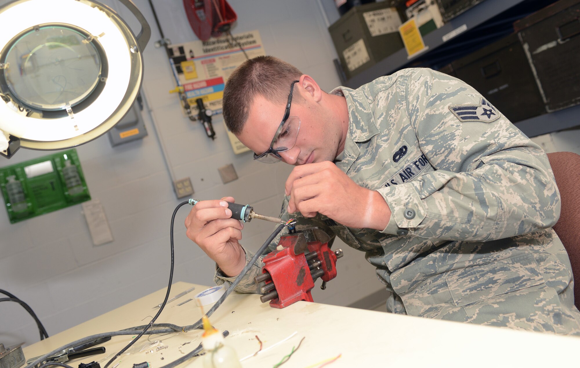 Senior Airman Michael Considine, an Avionics Specialist with the 185th Air Refueling Wing, Iowa Air National Guard, solders a connector to the end of a communications cable that will be used as part of a KC-135 interphone, on August 1, 2014. (U.S. Air National Guard photo by Master Sgt. Vincent De Groot/Released)