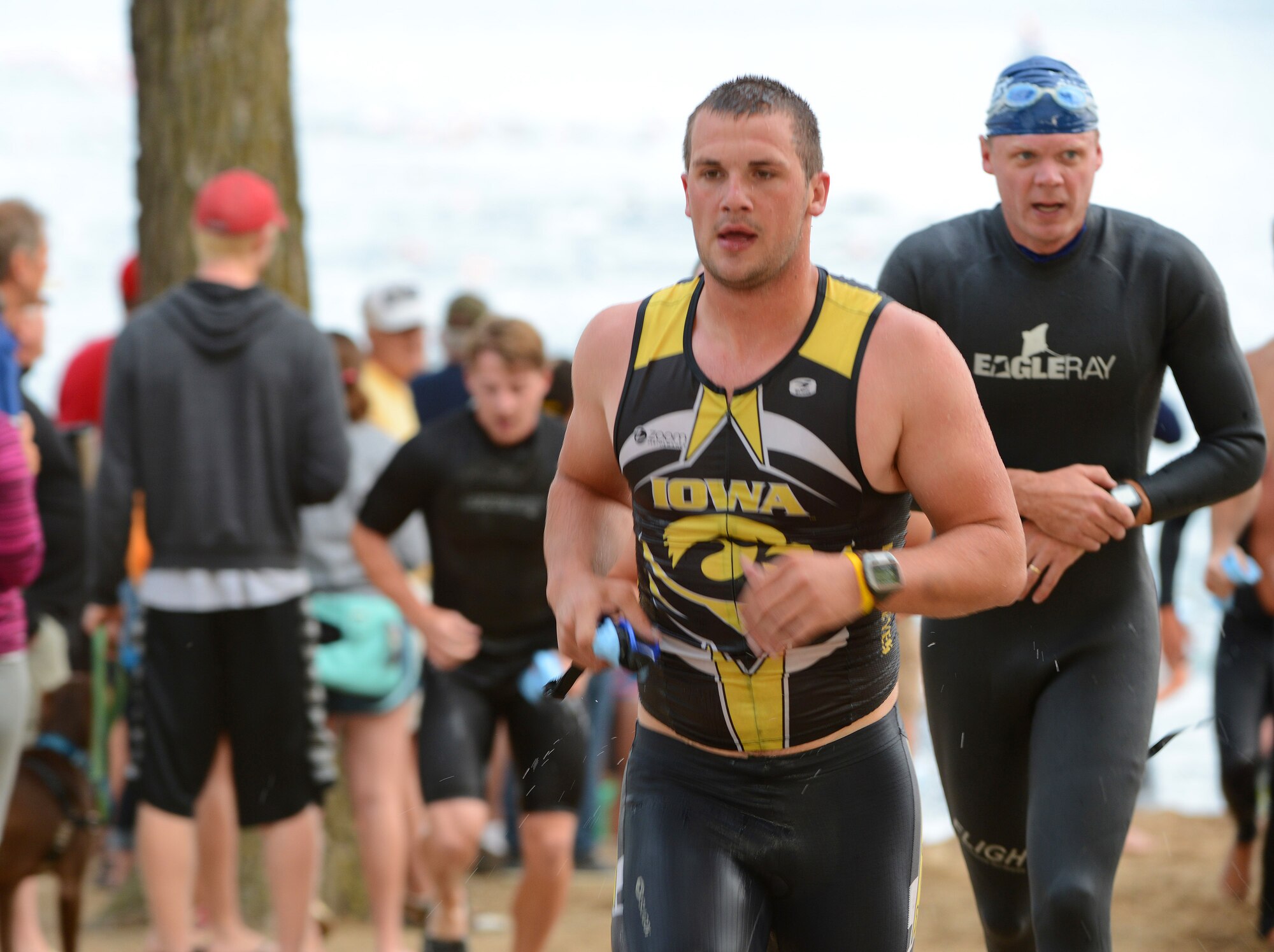 Senior Airman Michael Considine makes his way to the bicycle transition area after completing the half-mile swimming event during the University of Okoboji Triathlon in Okoboji, Iowa on July 19, 2014. Considine is a member of the Iowa Air National Guard in Sioux City, IA and is also a full time student. As an avid triathlete, Considine competes individually and as a member of the University of Iowa Triathlon team. (U.S. Air National Guard photo by Master Sgt. Vincent De Groot/Released)