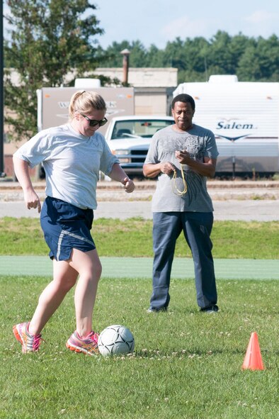 HANSCOM AIR FORCE BASE, Mass. – Capt. Michelle Laning, C3I and Networks Directorate Cyber Sustainment product support program manager, participates in the Fitness and Sports Center’s Dribble Time Soccer competition at the base track Aug. 18 as Larry Harvey, 66th Force Support Squadron recreation specialist, times her. Participants compete throughout August to see how fast they can make their way through five cones while dribbling a soccer ball. (U.S. Air Force photo by Mark Herlihy)