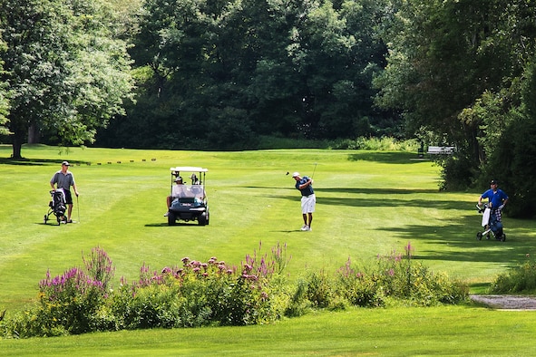 BEDFORD, Mass. – Marcus Wells hits a shot from the fairway during the Patriot Golf Course Club Championship that took place Aug. 15 and 16 here, while Robert John (left), Don McInnis (seated in golf cart), and John Macsata (right) look on. Winners of each division are as follows: Junior Club Champion, Patrick Logue III; Club Champion, Don McInnis; Senior Club Champion, Robert John; Super Senior Club Champion, Al Harrington; Women’s Club Champion, Arlene Deardorff; and Senior Women’s Club Champion, Wendy Rudner. (U.S. Air Force photo by Walter Santos)