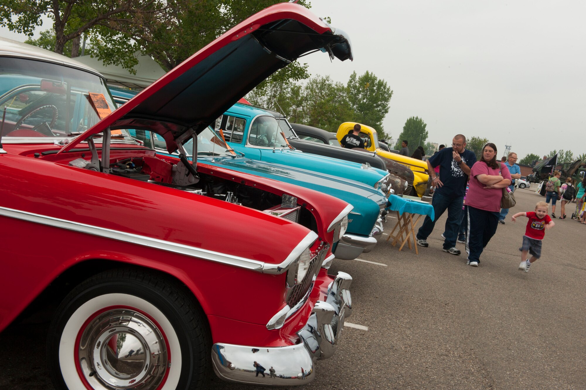 A family looks at cars during the Annual Summer Block Party on Minot Air Force Base, N.D., Aug. 16, 2014. The event featured a burger burn, inflatables, and the Show and Shine Car Show. (U.S. Air Force photo/Airman 1st Class Apryl Hall)