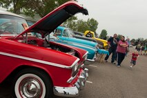 A family looks at cars during the Annual Summer Block Party on Minot Air Force Base, N.D., Aug. 16, 2014. The event featured a burger burn, inflatables, and the Show and Shine Car Show. (U.S. Air Force photo/Airman 1st Class Apryl Hall)