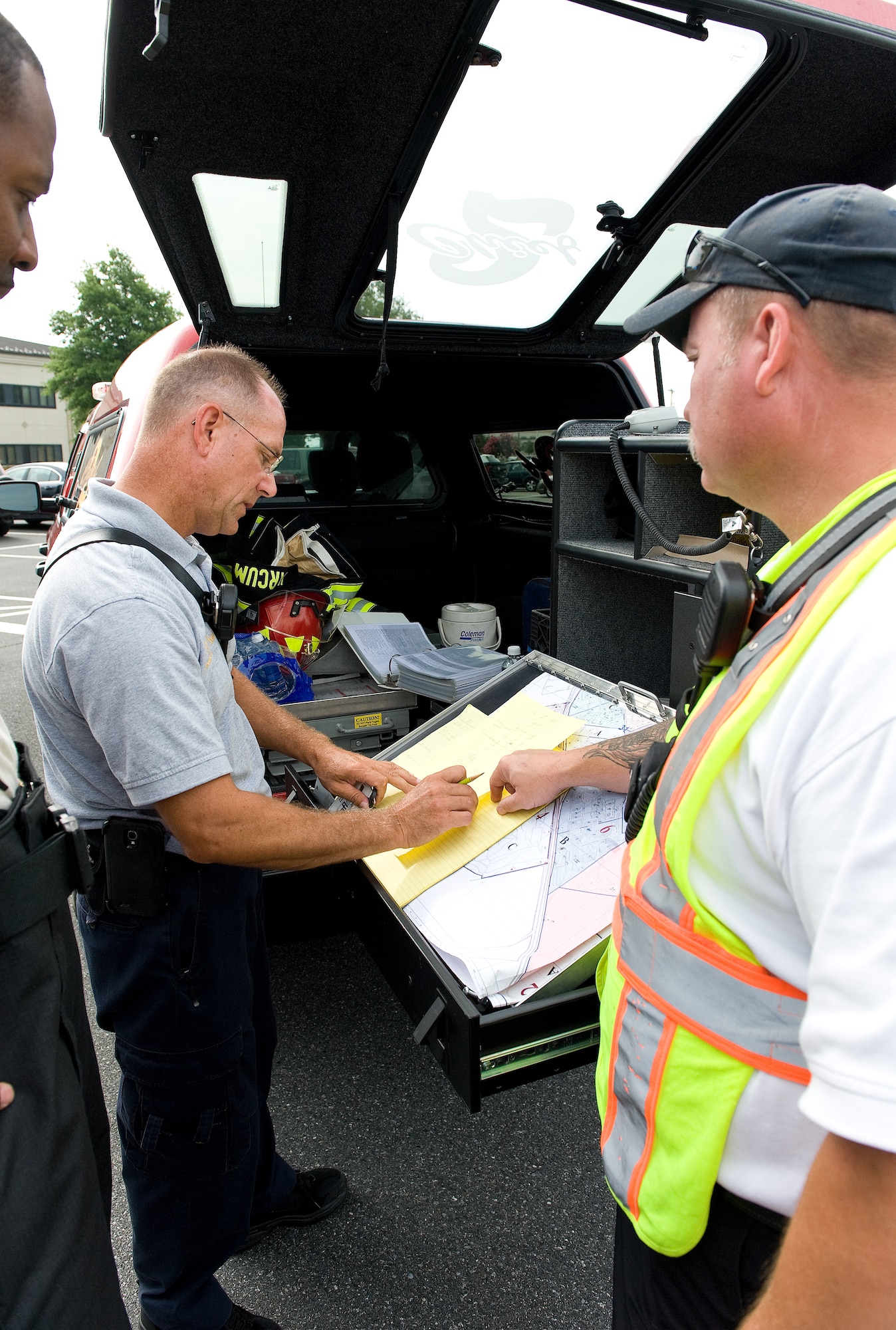 Joseph Mriss, left, assistant chief of operations and John Melvin, right, safety officer, both from the 436th Civil Engineer Squadron Fire Department, review notes and grid map during an active shooter exercise Aug. 1, 2014, at Dover Air Force Base, Del. Mriss was the on-scene commander for this particular scenario during a major accident response exercise.(U.S. Air Force photo/Roland Balik)