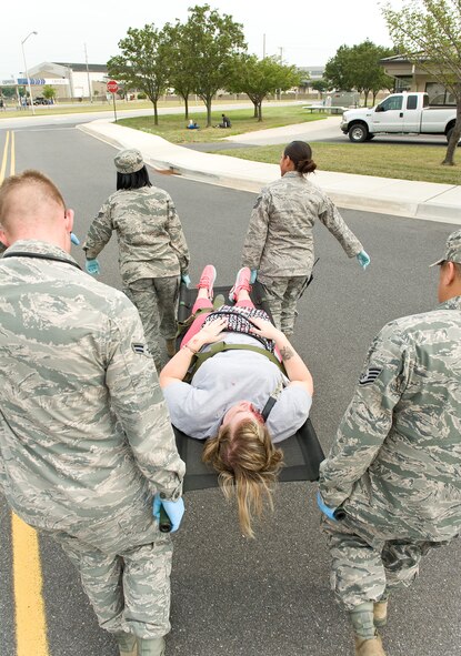 Airman 1st Class Kylie Sisson, 436th Medical Operations Squadron pediatric medical technician, is carried away by 436th Medical Group personnel during an active shooter exercise Aug. 1, 2014, at Dover Air Force Base, Del. Sisson was one of many Team Dover members who had active roles on the first day of a major accident response exercise. (U.S. Air Force photo/Roland Balik)