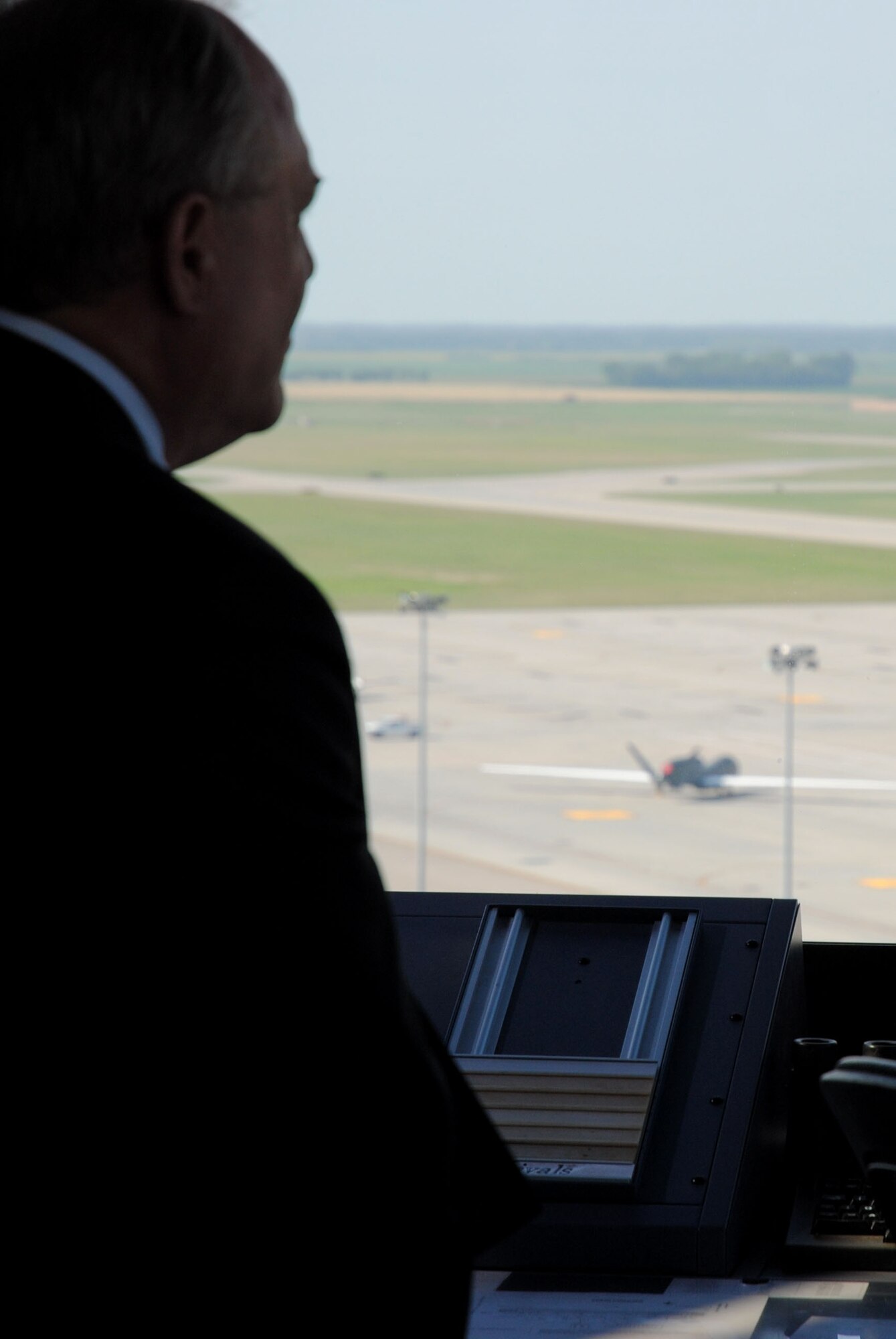 Jim Williams, Federal Aviation Administration Unmanned Aircraft Systems Integration Office manager, observes an RQ-4B Global Hawk parked on the flightline from the air traffic control tower on Grand Forks Air Force Base, N.D., on Aug. 15, 2014. Williams visited the Radar Approach Control Tower, as one of the stops on tour incorporated into his official visit to the base. The RAPCON tower is the primary facility used by the Air Force for directing approaches and departures of all aircraft in and out of the installation, to include Unmanned Aerial Vehicles. (U.S. Air Force photo/Staff Sgt. Luis Loza Gutierrez)