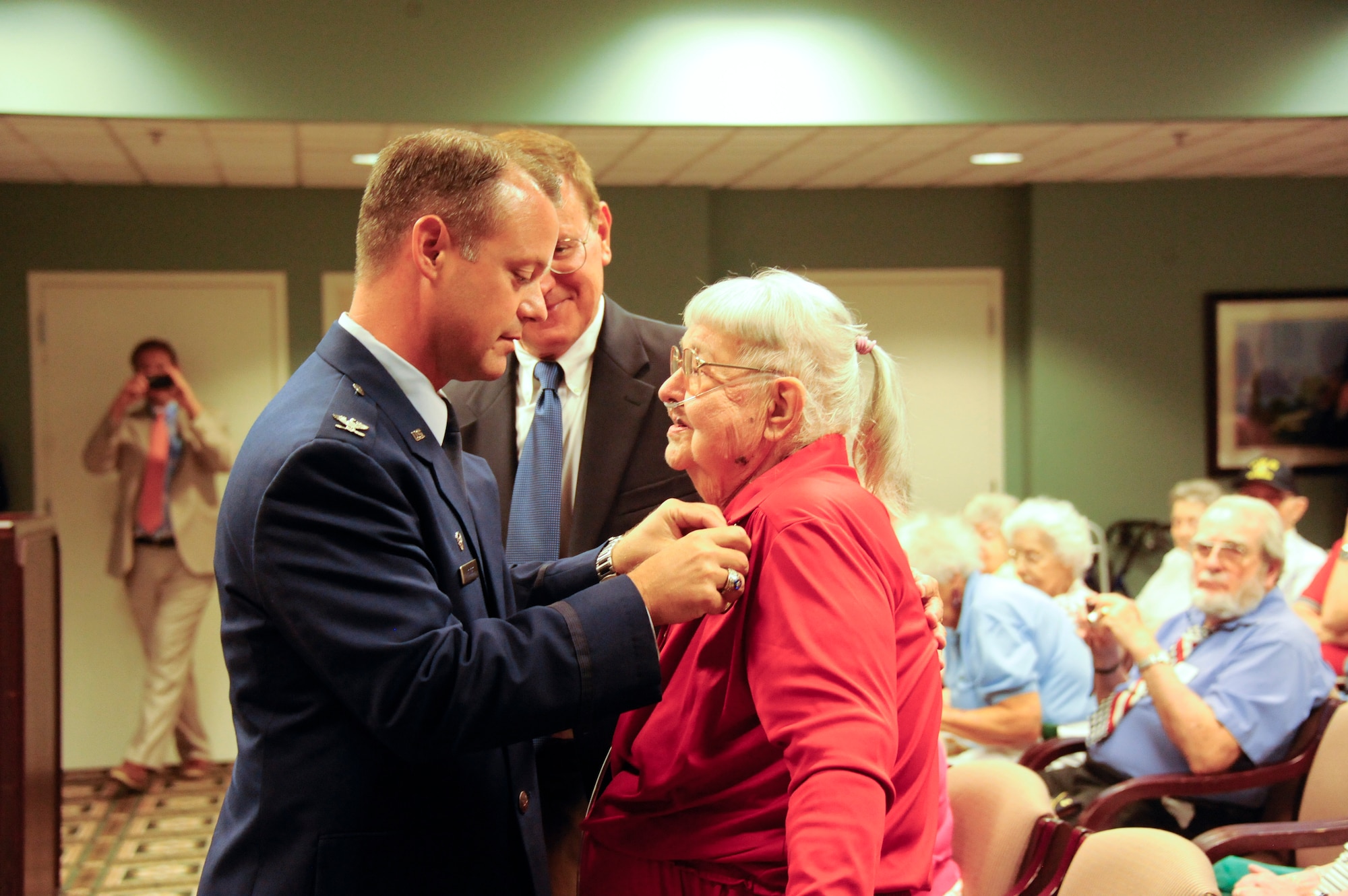 Air Force Col. James C. Hodges, Joint Base McGuire-Dix-Lakehurst and 87th Air Base Wing commander, JB MDL, N.J., presented Jean Lawler, spouse of deceased Lt. Col. Lawrence T. Lawler, a Prisoner of War Medal recipient, as Larry Lawler Jr., son of POW, looks on at the Bristol Glen Continuing Care Retirement Community in Newton, N.J., Aug. 11, 2014. The POW medal was presented for Lawler's internment during World War II, when he and his crew were forced to bail out from their severely damaged B-17 Flying Fortress over neutral Switzerland. Lawler was imprisoned from March to December 1944 before successfully escaping from the infamous Wauwilermoos Prison. The POW medal was authorized by Congress for any person who served honorably as a POW after April 5, 1945. It is estimated that 142,000 U.S. service members were held as prisoners in WWI, WWII, Korean and Vietnam War. The medal recognizes the special service POWs gave to their country and the suffering and anguish they endured while incarcerated. (U.S. Air Force photo by Pascual Flores/Released)
