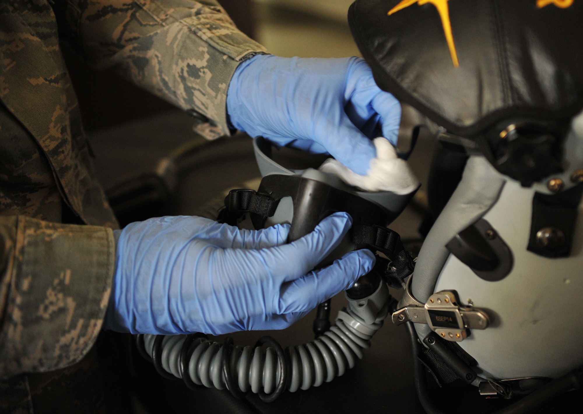 Senior Airman Jeffrey Berry, 493rd Fighter Squadron aircrew flight equipment technician, cleans and preforms post-flight checks on helmets used by pilots Aug. 15, 2014. Without the protective gear supplied to them by AFE Airmen, pilots wouldn’t be able to fly safely. (U.S. Air Force photo/Senior Airman Hailey Haux)