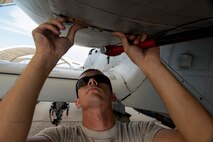 U.S. Air Force Airman 1st Class Sterling Vaughan, 74th Aircraft Maintenance Unit crew chief, reinstalls panels to an A-10C Thunderbolt II engine at Moody Air Force Base, Ga., Aug. 18, 2014. Maintainers work around the clock to ensure Moody’s A-10s remain mission ready at all times. (U.S. Air Force photo by Staff Sgt. Jamal D. Sutter/Released)