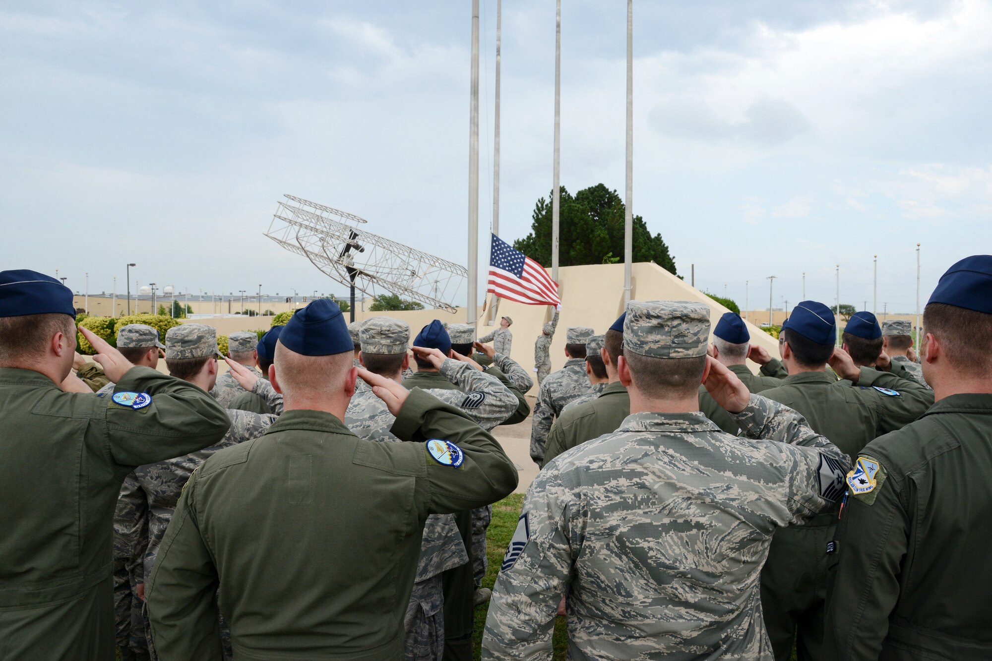 Members of the 960th Airborne Air Control Squadron and others from the 552nd Air Control Wing stand at attention as the flag at the Wright Flyer is lowered during the inaugural Team Tinker Retreat Ceremony on Aug. 8. The idea for a monthly retreat ceremony came from 72nd Air Base Wing Command Chief Master Sgt. Thomas Christopher as a way to promote more Air Force pride. Squadrons or groups are invited to participate, with help from the Tinker Honor Guard. To host a retreat ceremony, contact Master Sgt. Robert Angel, 552nd Maintenance Squadron, at 734-5999 or Master Sgt. Brian Partido, 963rd Airborne Air Control Squadron, at 734-5196. (Air Force photo by Kelly White)