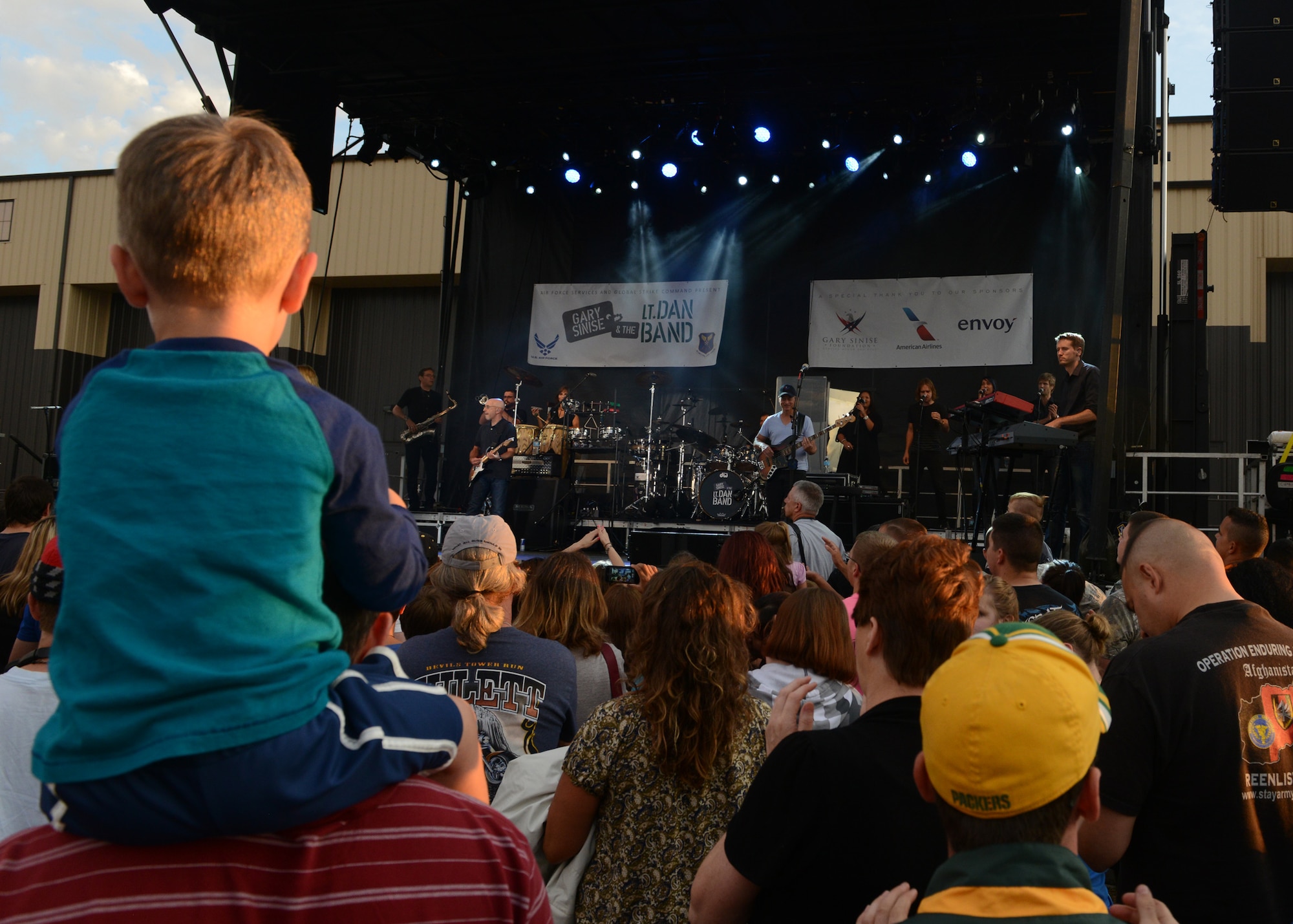 A crowd listens to Gary Sinise and the Lt. Dan Band perform during a free concert Aug. 15 at Malmstrom Air Force Base, Mont. The Lt. Dan Band, a cover band named after a wounded soldier Sinise portrayed in the film “Forrest Gump,” and has been entertaining and visiting U.S. service members all over the world for more than a decade. (U.S. Air Force photo/Senior Katrina Heikkinen)