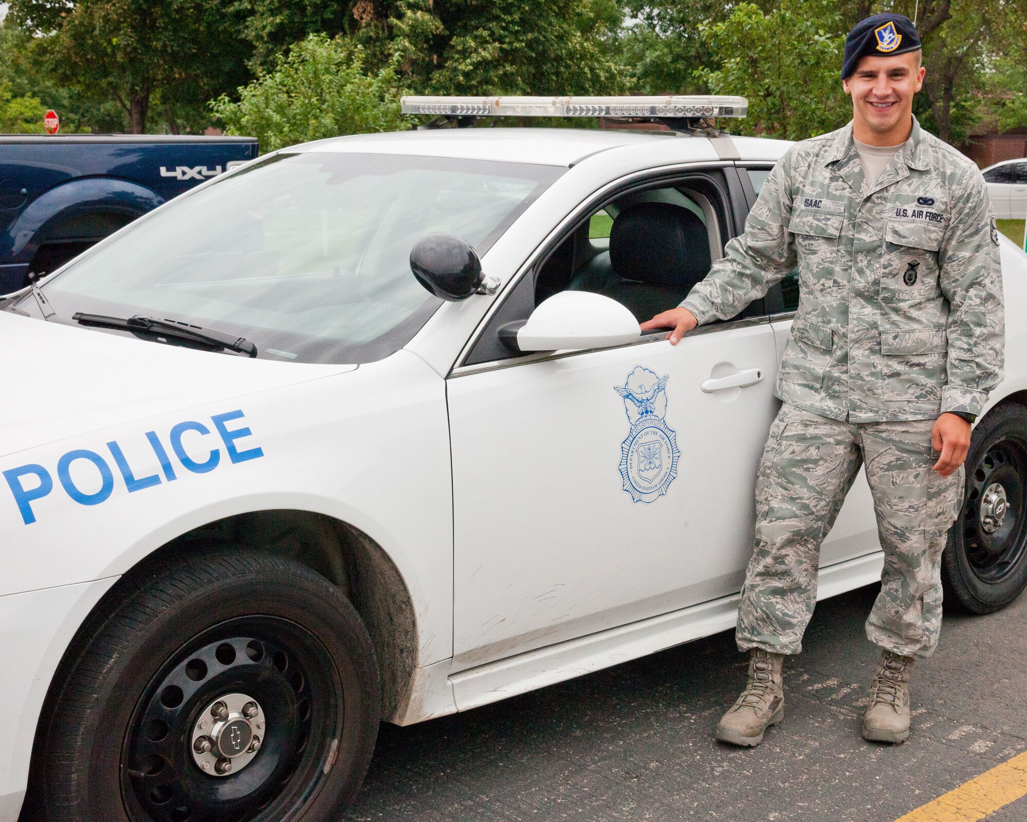 Senior Airman Jeffrey Isaac, 934th Security Forces Squadron patrolman, poses next to his patrol car he uses in his job at Minneapolis St. Paul Air Resrve Station. (U.S. Air Force photo/Shannon McKay)