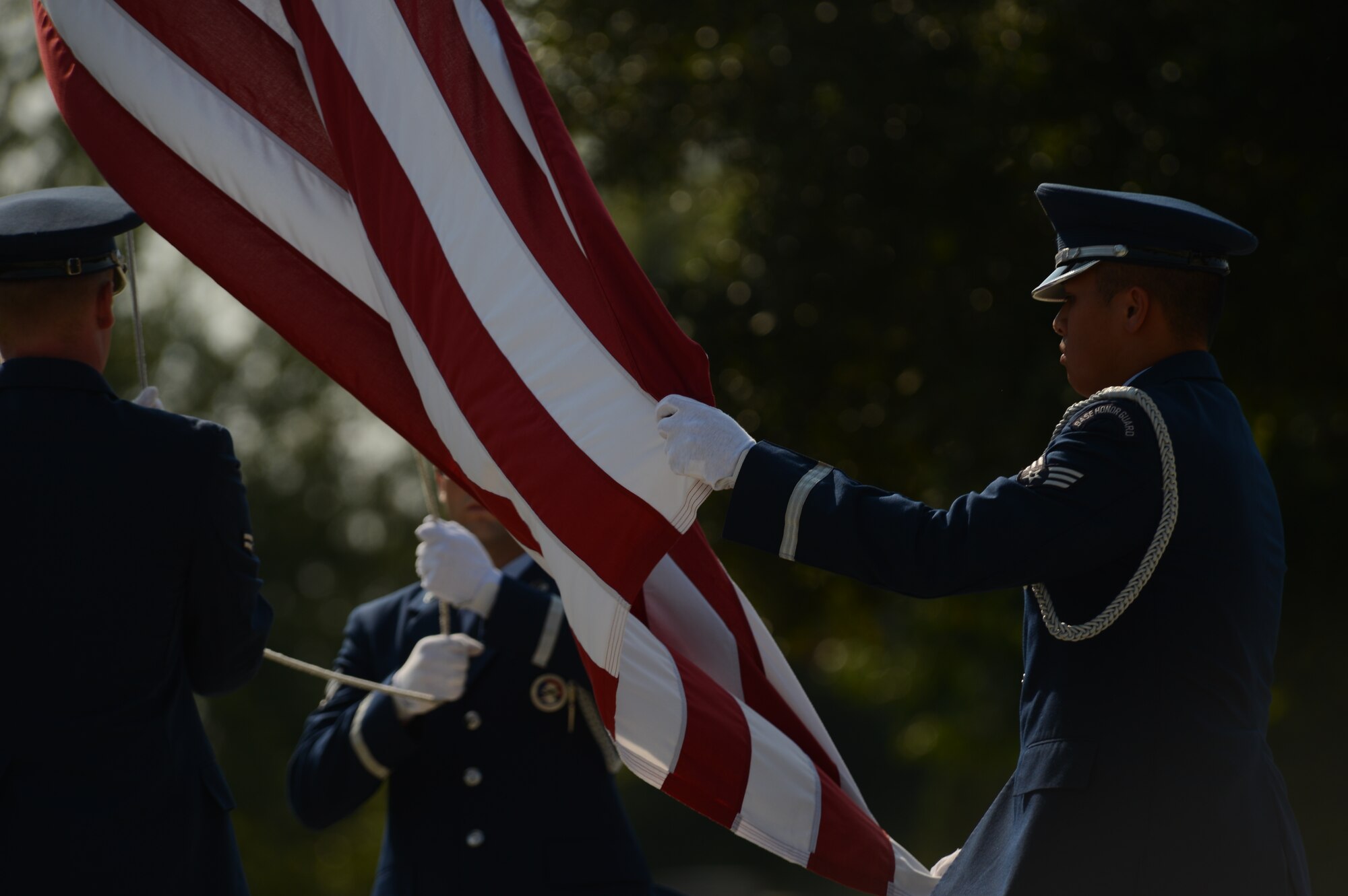 Three 20th Force Support Squadron Base honorguardsmen lower the American flag at a retreat ceremony at Shaw Air Force Base, S.C., Aug. 7, 2014. The retreat ceremony signals the end of the duty day and serves as a ceremony to pay respect to the American flag. (U.S. Air Force photo by Airman 1st Class Jensen Stidham/Released)