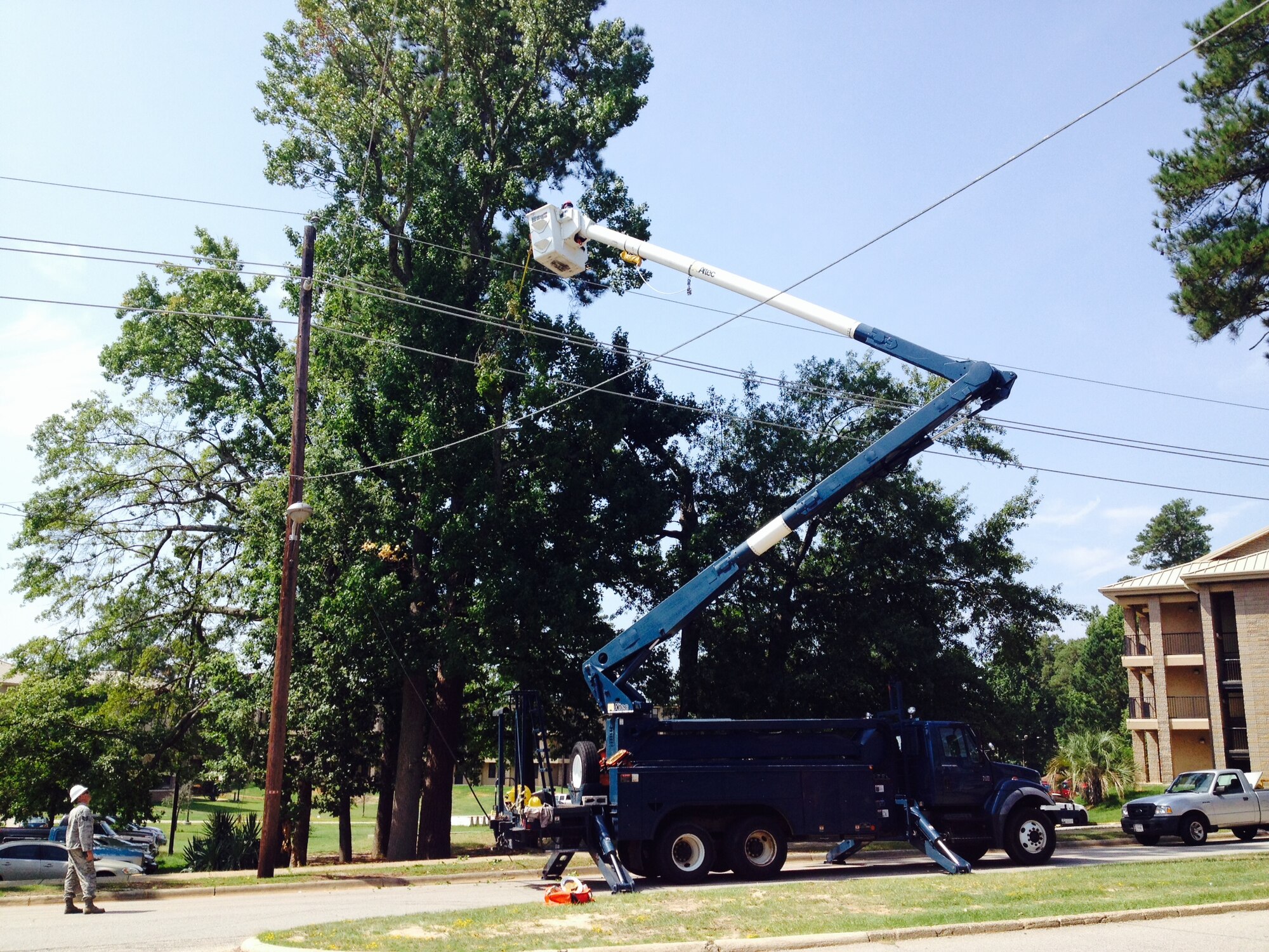 20th Civil Engineer Squadron members remove a broken tree branch from a power line at Shaw Air Force Base, S.C., Aug. 18, 2014. During the blackout, 20th CES and 20th Security Forces Squadron responded quickly to remove the obstruction and return power to the base. (U.S. Air Force photo by Lt. Col. Joseph Rodriguez/Released)