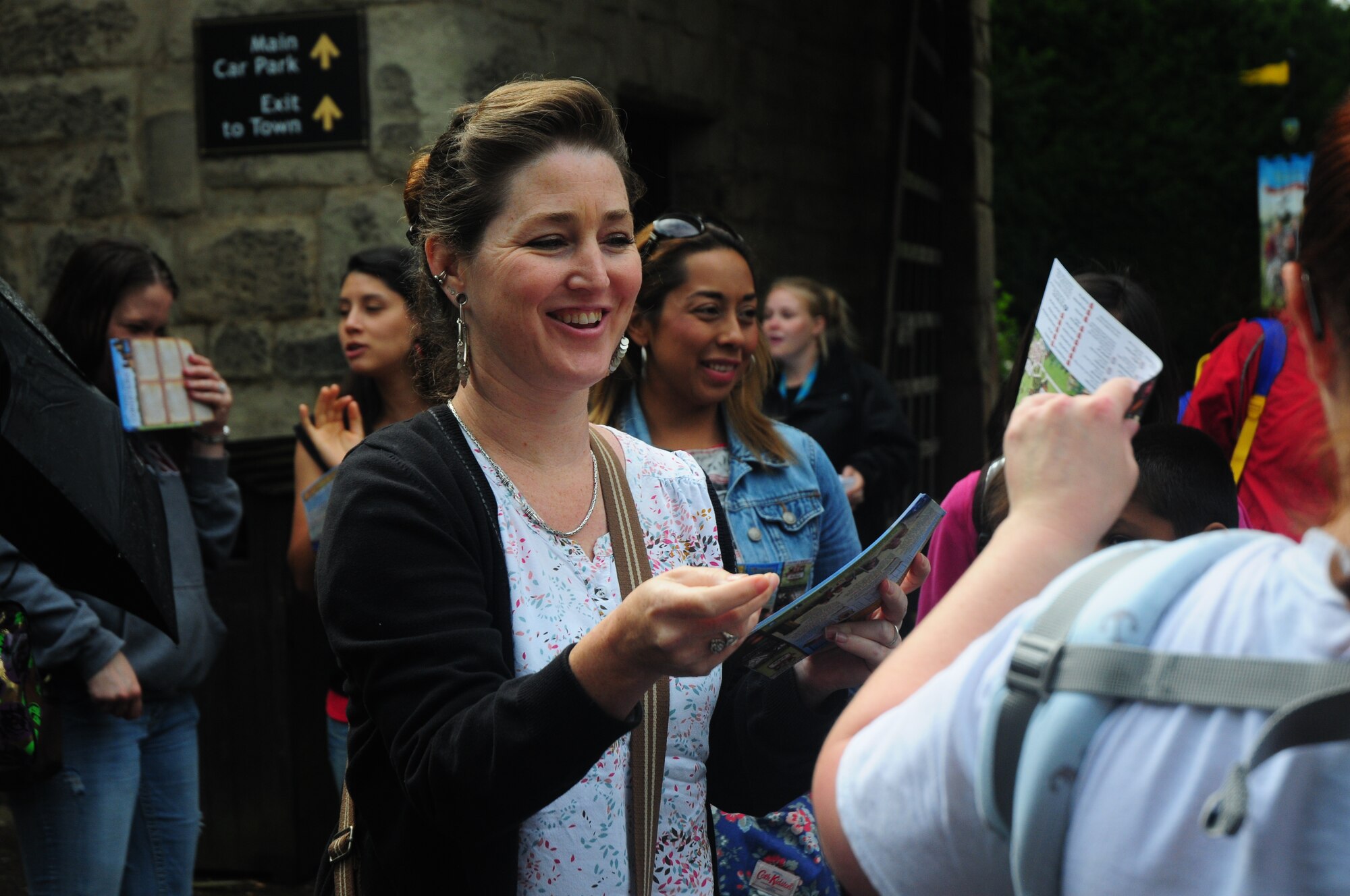 Jill Becker, 48th Fighter Wing Key Spouse member and trip volunteer coordinator, hands out maps to the families of deployed Airmen during a Chaplain Corps resiliency trip to Warwick Castle, Aug. 14, 2014. Eighty-four family members, representing a variety of 48th FW personnel, took advantage of the opportunity to get off base and explore the local community. (U.S. Air Force Photo by Airman 1st Class Amanda Sampson/Released)