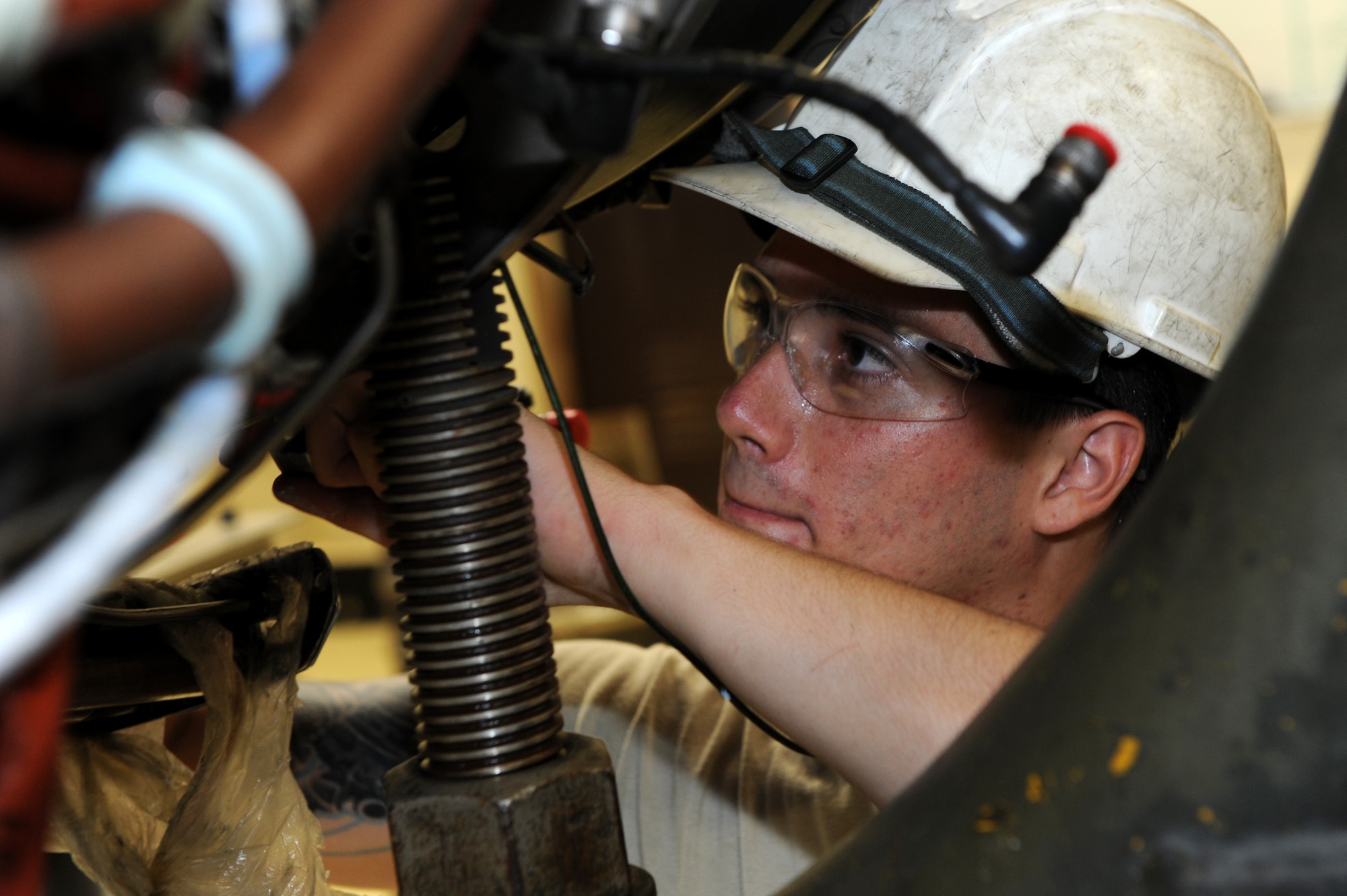 U.S. Air Force Airman 1st Class Francisco Cruz, 18th Component Maintenance Squadron aerospace propulsion apprentice, finishes installing a low pressure turbine on the TF-34 engine on Kadena Air Base, Japan, Aug. 19, 2014. The TF-34 engine is part of an A-10 Warthog assigneds to Osan Air Base, Korea. (U.S. Air Force photo by Airmen 1st Class Stephen G. Eigel/Released) 