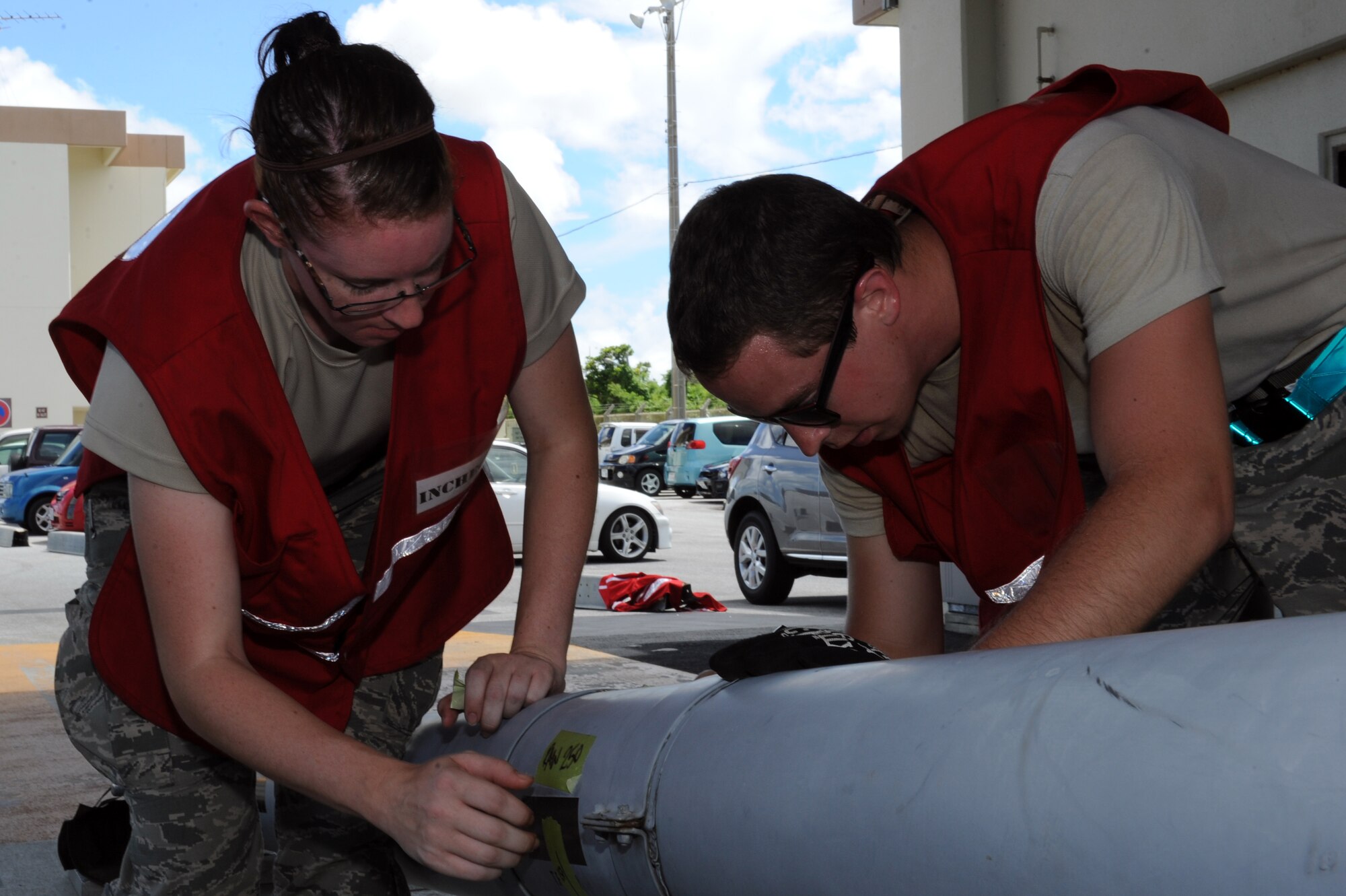 U.S. Air Force Airman 1st Class Whitney Mitchell, 18th Logistics Readiness Squadron northside aircraft parts store journeyman, and Senior Airman Micah Franke, 18th LRS central storage journeyman, peel inaccurate labels from cargo on Kadena Air Base, Japan, Aug. 19, 2014. The goal of the MFE is to enforce unit self-assessment year-round, keeping units accountable for non-compliance and reporting how each unit prepares to solve the problems through self-analysis and implementation. (U.S. Air Force photo by Airman 1st Class Zade C. Vadnais/Released)   