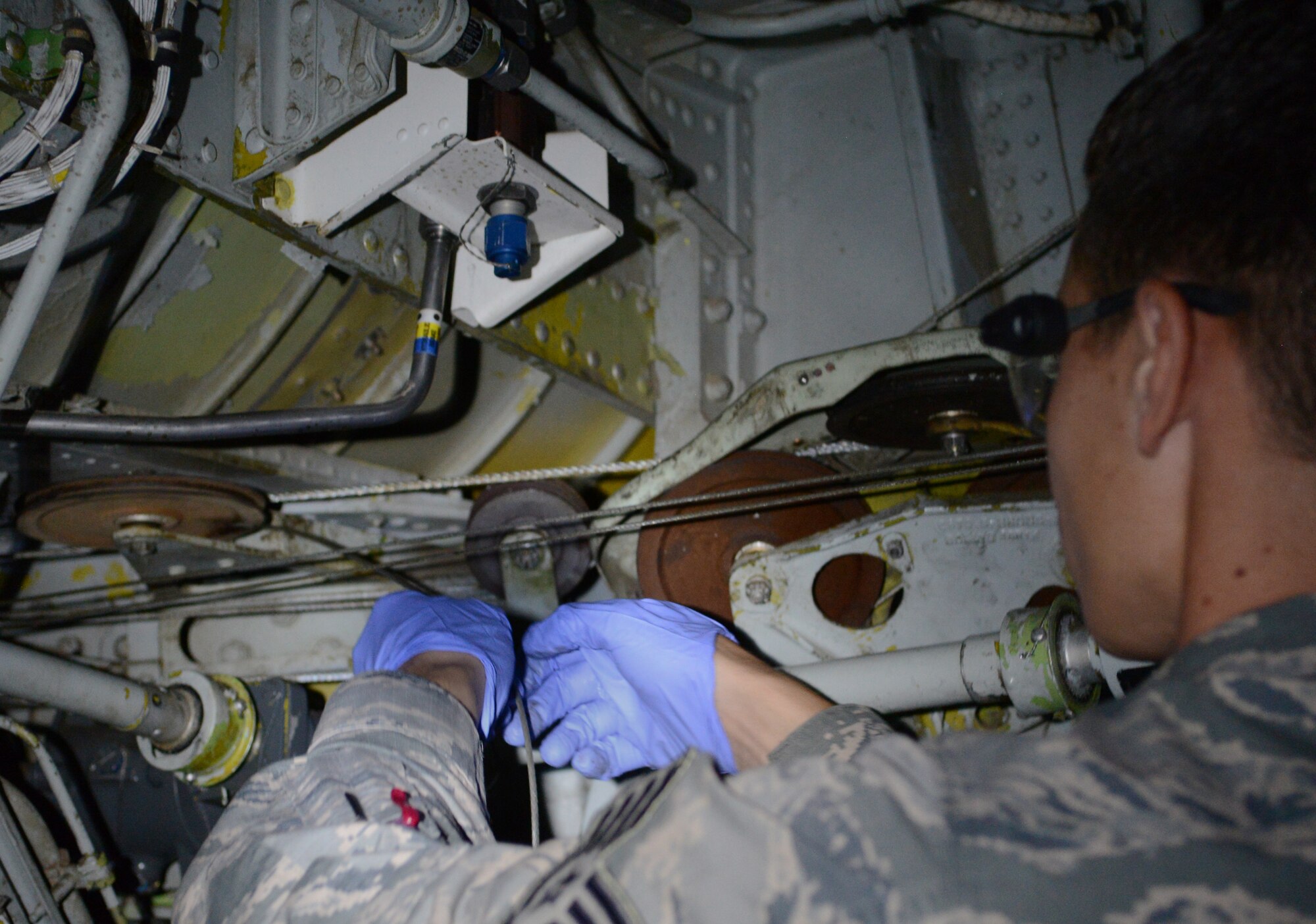 U.S. Air Force Staff Sgt. James Roddel, 100th Maintenance Squadron repair and reclamation journeyman from Libertyville, Ill., pulls a cable through the length of a wing on a KC-135 Stratotanker during an isochronal inspection, which occur at set intervals for each plane, Aug. 14, 2014, on RAF Mildenhall, England. Because of blending in the cable, which is identified by the metal strands of wire in the cable being pushed together and appearing as one, the cable needed to be replaced. (U.S. Air Force photo/Airman 1st Class Dillon Johnston/Released)