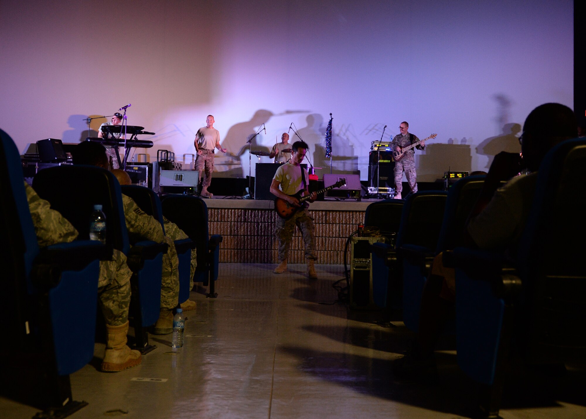 Tech. Sgt. John Kukan, Air Forces Central Band Starlifter guitarist, plays as solo during the bands dedicated show for the 379th Expeditionary Security Forces Squadron. Prior to the show, the 379th ESFS military working dog flight gave a show of force and explosive detection demonstration at the kennel, which was a first for the entire band and doubled as a training opportunity for the MWDs. (U.S. Air Force photo by Staff Sgt. Shawn Nickel/Released)