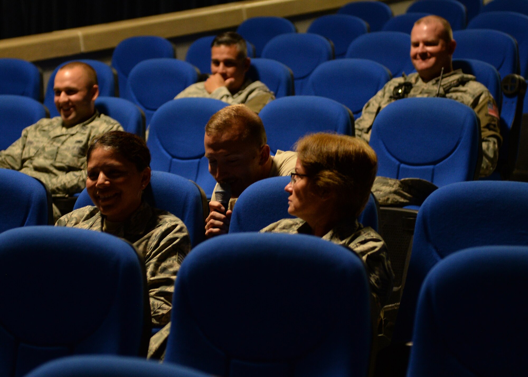 Airman 1st Class Denver Murphy, U.S. Air Forces Central Band Starlifter male vocalist, sneaks behind members of the 379th Expeditionary Security Forces Squadron during the bands dedicated show for the squadron. Prior to the show, the 379th ESFS military working dog flight gave a show of force and explosive detection demonstration at the kennel, which was a first for the entire band and doubled as a training opportunity for the MWDs. (U.S. Air Force photo by Staff Sgt. Shawn Nickel/Released)