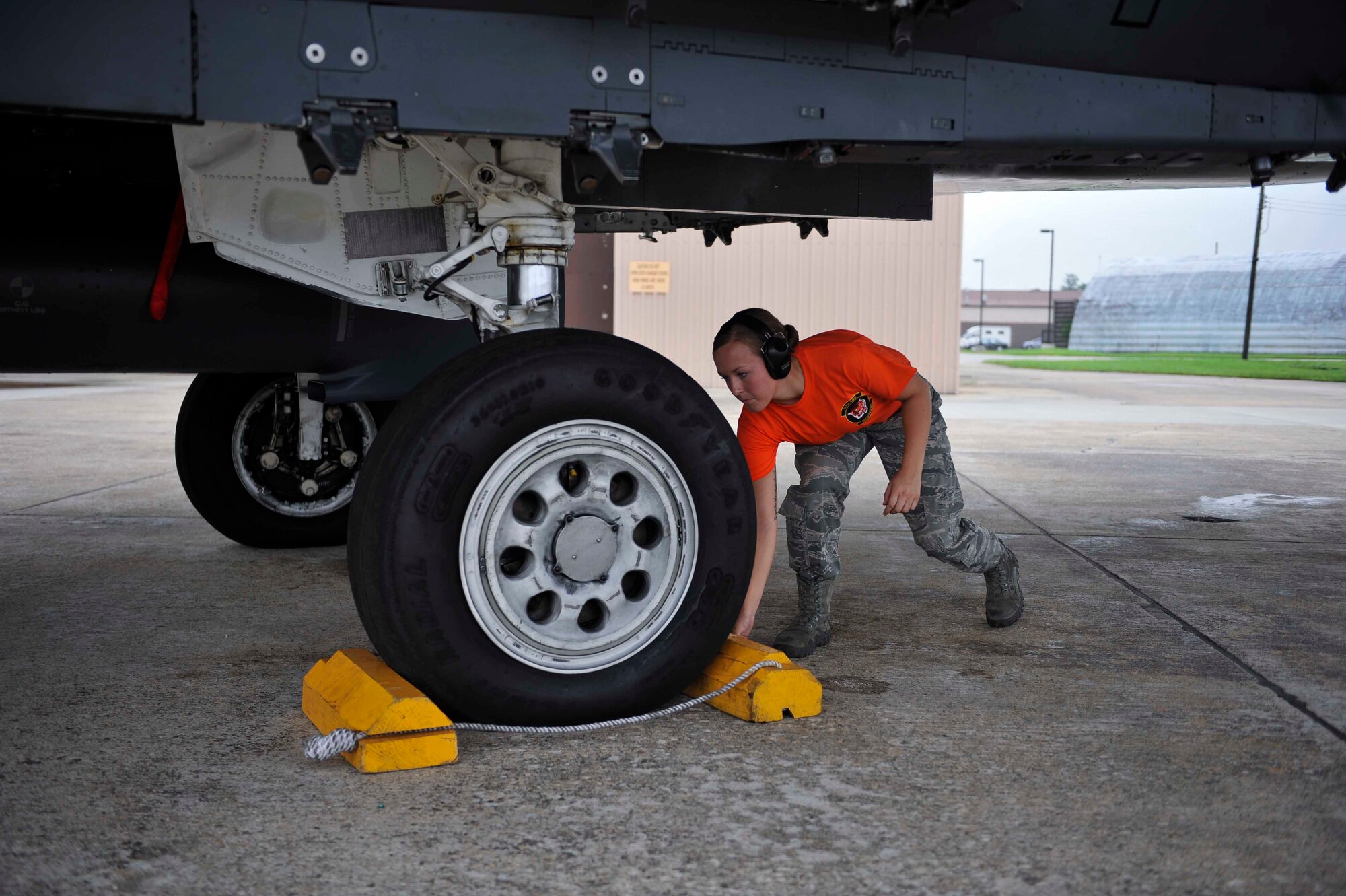 Airman 1st Class Shelby Livingston, 391st Aircraft Maintenance Unit weapons load crew member, Mountain Home Air Force Base, Idaho,  removes the wheel chocks during a pre-flight inspection on an F-15 Strike Eagle Osan Air Base, Republic of Korea, Aug. 15, 2014. Wheel chocks are wedges that prevent the aircraft from moving. (U.S. Air Force photo/Senior Airman David Owsianka)