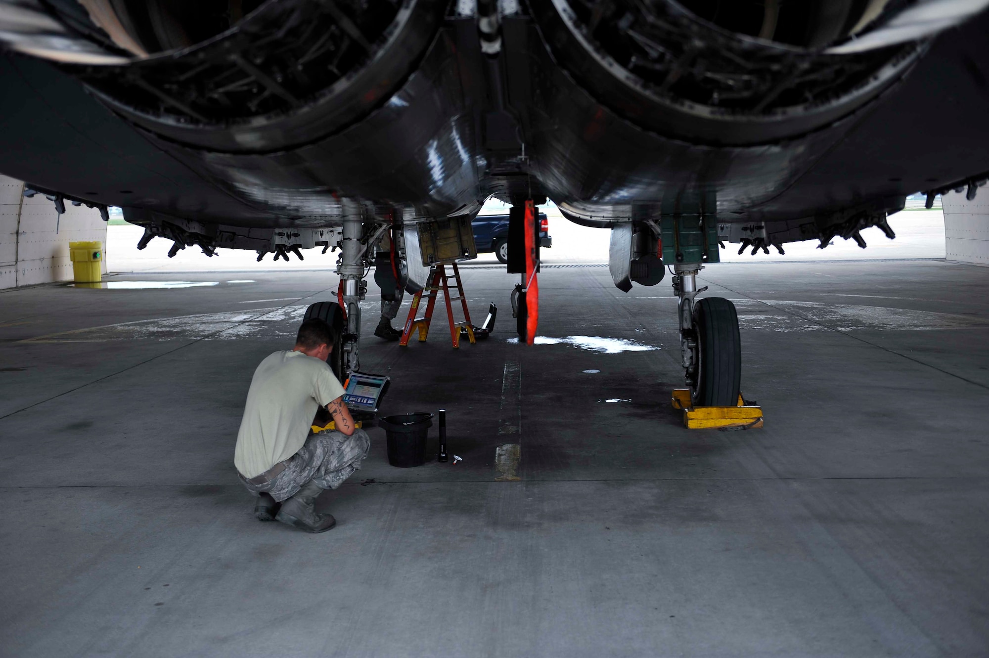 Airman 1st Class Blake Destasio, 391st Aircraft Maintenance Unit crew chief, Mountain Home Air Force Base, Idaho, looks at a technical order toughbook prior to checking the engine oil on an F-15 Strike Eagle in a hangar on Osan Air Base, Republic of Korea, Aug. 14, 2014. TO toughbooks are used to facilitate maintenance on aircraft by providing Airmen with reference material. (U.S. Air Force photo/Senior Airman David Owsianka)