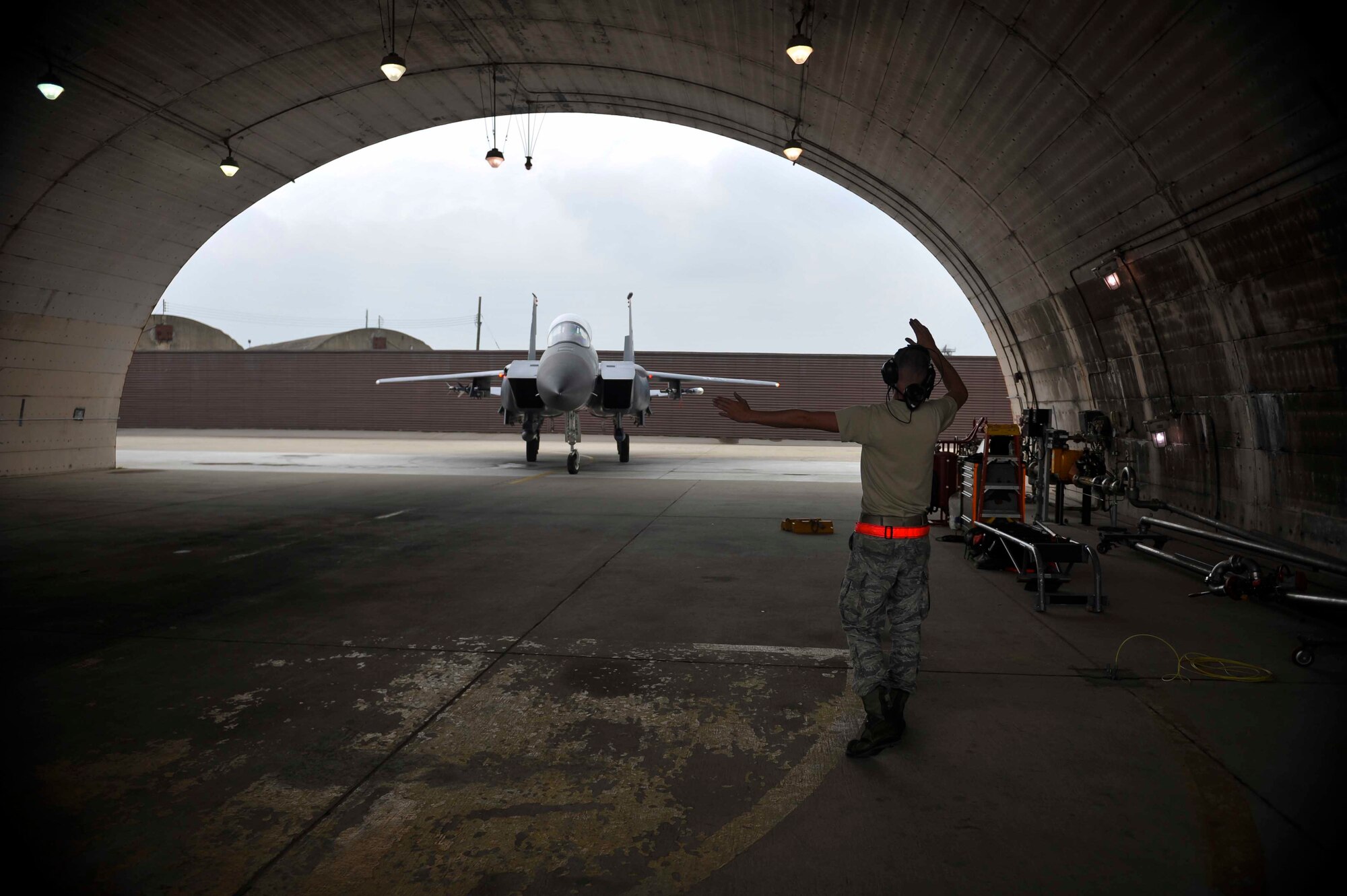 Senior Airman Brian Radtka, 391st Aircraft Maintenance Unit crew chief, Mountain Home Air Force Base, Idaho, marshals an F-15 Strike Eagle into a hangar on Osan Air Base, Republic of Korea, Aug. 14, 2014. The aircraft received maintenance work once inside the hangar. (U.S. Air Force photo/Senior Airman David Owsianka)