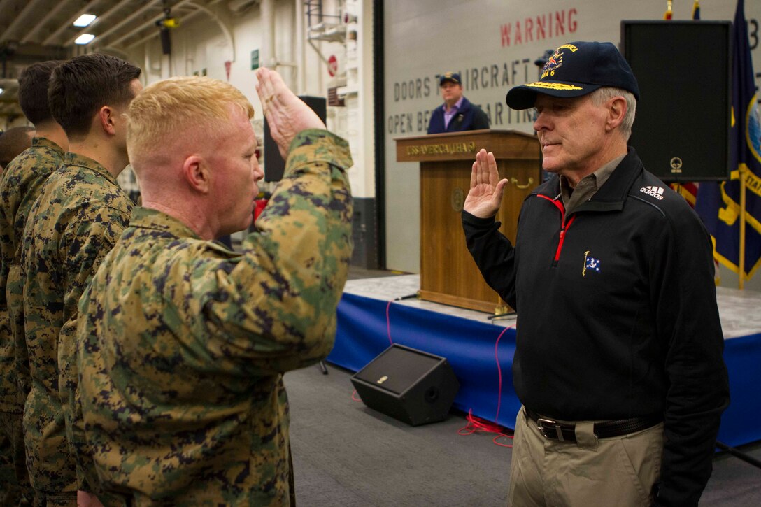 Sergeant Maj. William Schaffer, sergeant major of Special Purpose Marine Air Ground Task Force South, and a native of Roanoke, Va., recites the oath of enlistment with the Secretary of the Navy Ray Mabus during his reenlistment held aboard the future amphibious assault ship USS America (LHA 6), Aug. 19, 2014. The reenlistment and promotions were held prior to an all hands meeting where Mabus addressed the Marines and Sailors with America and SPMAGTF-South. Mabus also toured the ship, had dinner with Marines and Sailors in the mess deck and attended an ice cream social. Visits like this remind the Marines and Sailors with America and the SPMAGTF of the significance of the work they are doing. SPMAGTF-South is embarked aboard America in support of her maiden transit, “America Visits the Americas.” Through partner-nation activities, theater security events and key leader engagements, the transit aims to demonstrate the flexibility, utility and unparalleled expeditionary capability the Navy-Marine Corps team provides our nation and partners. (U.S. Marine Corps Photo by Cpl. Donald Holbert/ Released)