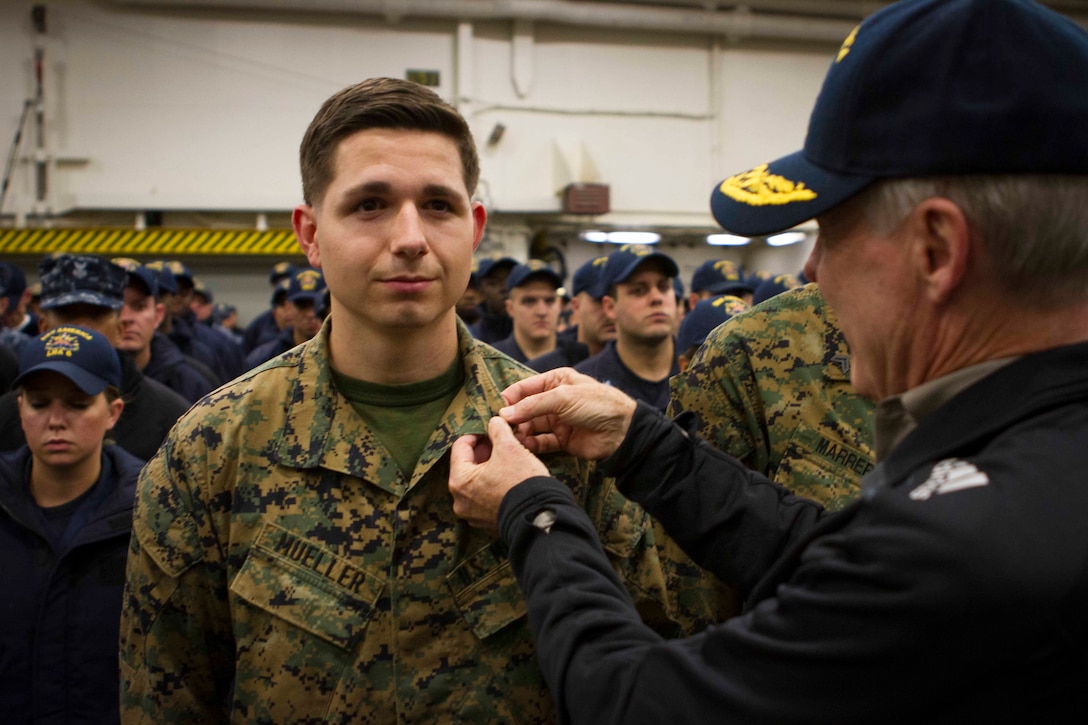 Cpl. Carlton Mueller, a Marine with the Command Element of Special Purpose Marine Air Ground Task Force South, and a native of Dothan, Ala., is promoted by Secretary of the Navy Ray Mabus during a reenlistment and promotion ceremony held aboard the future amphibious assault ship USS America (LHA 6), Aug. 19, 2014. The reenlistment and promotions were held prior to an all hands meeting where Mabus addressed the Marines and Sailors with America and SPMAGTF-South. Mabus also toured the ship, had dinner with Marines and Sailors in the mess deck and attended an ice cream social. Visits like this remind the Marines and Sailors with America and the SPMAGTF of the significance of the work they are doing. SPMAGTF-South is embarked aboard America in support of her maiden transit, “America Visits the Americas.” Through partner-nation activities, theater security events and key leader engagements, the transit aims to demonstrate the flexibility, utility and unparalleled expeditionary capability the Navy-Marine Corps team provides our nation and partners. (U.S. Marine Corps Photo by Cpl. Donald Holbert/ Released)