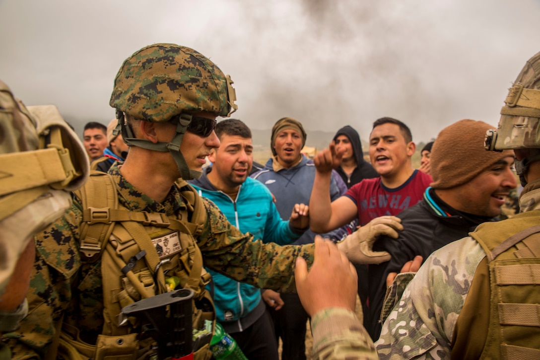 A Marine from 1st Battalion, 23rd Marines attempts to control a crowd of unruly citizen role players during a training scenario designed to simulate a major natural disaster in Pichidangui, Chile August 18, 2014, as part of Partnership of the Americas 2014. Representatives from Argentina, Brazil, Canada, Chile, Colombia, Mexico, Paraguay, and the United States are participating in POA 2014 from August 11-22, 2014. This exercise is designed to enhance joint and combined interoperability, increase the combined capability to execute Amphibious Operations, Peace Support Operations, and Humanitarian Assistance/Disaster Relief missions, and further develop strong and lasting relationships the U.S. Marine Corps has established with partner nation’s naval infantries/marine corps.